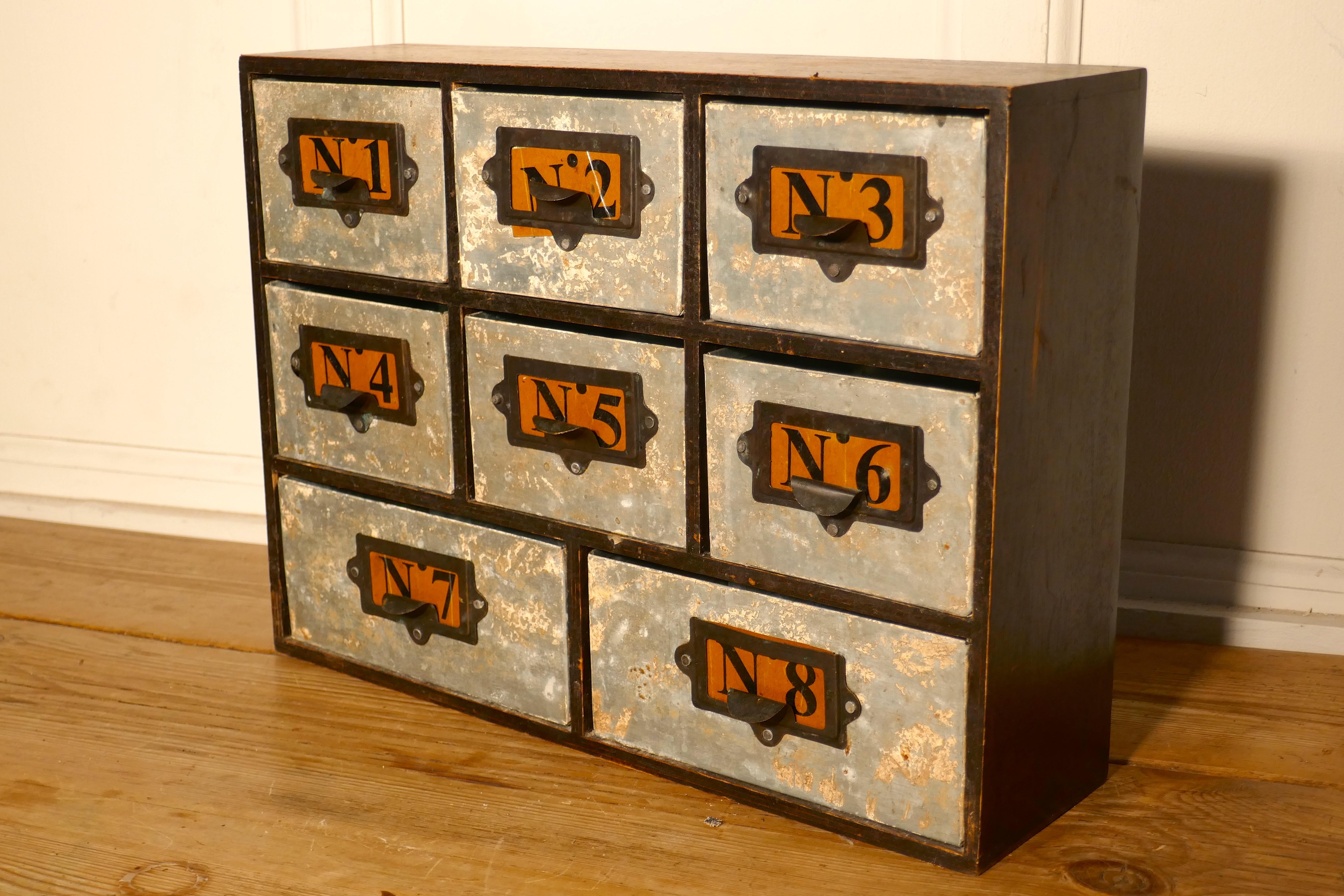 Industrial collectors organiser drawers

I useful piece, this 8 drawers chest has metal drawers set into a pine cabinet, the drawers are numbered 1-8, the labels are paper, these are set into a combined label holder/handle
The little chest is 18”