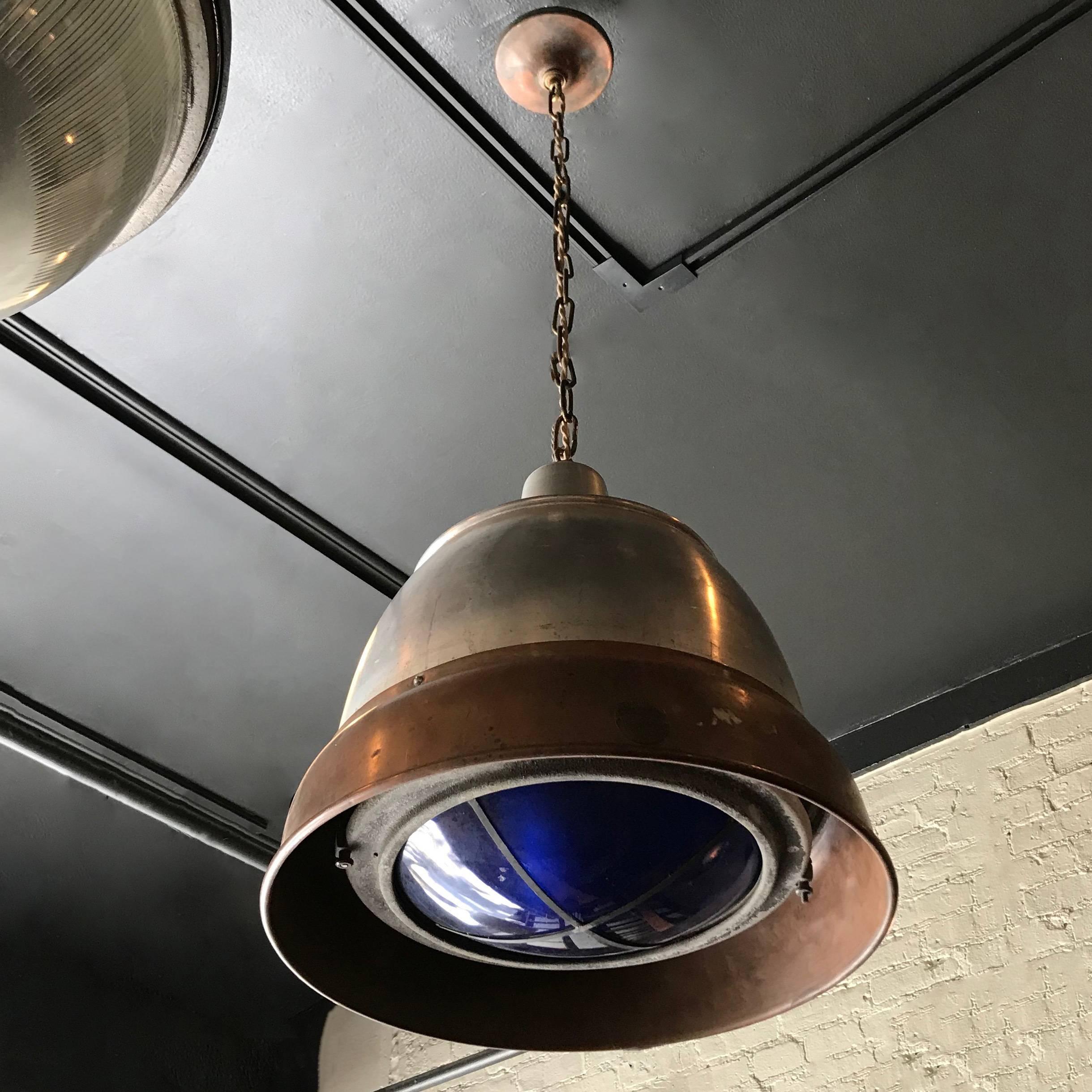 Large, industrial pendant light by Macbeth features a copper and aluminium dome shade with blue glass filter shade for daylight color correction, hangs on a chain with matching canopy. Overall height is 45 inches.