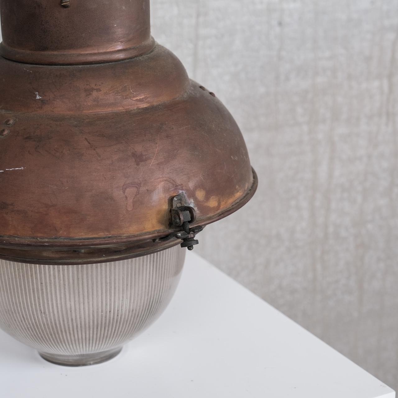 A large industrial pendant light.

France, circa 1930s.

Copper and prismatic glass.

Since re-wired and PAT tested.

Location: Belgium Gallery.

Dimensions: 55 H x 30 diameter in cm.


