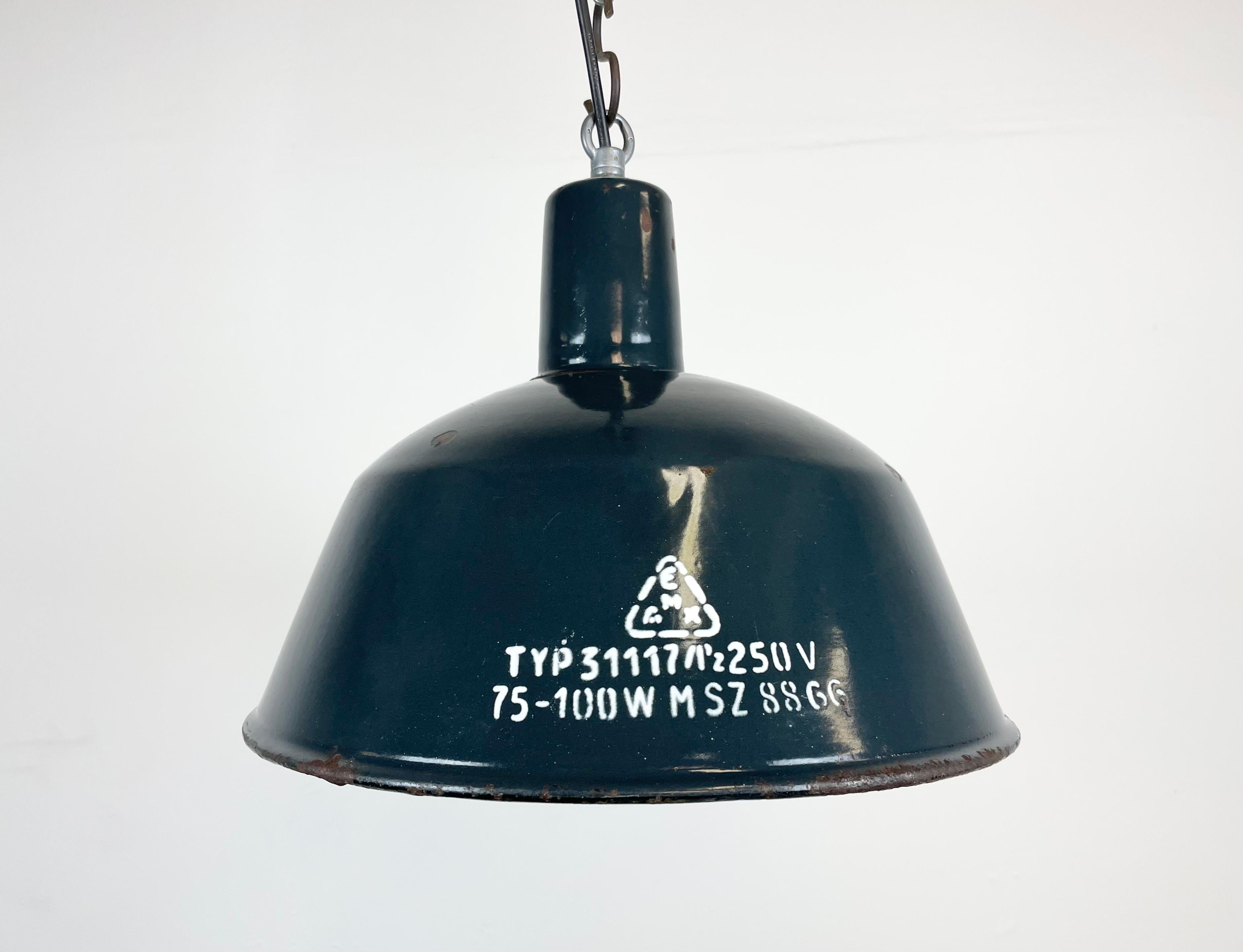 This industrial lamp was made by EMAX in Hungary during the 1960s. It features a dark blue enamel shade with white enamel interior and iron top. New porcelain socket requires E 27 light bulbs. New wire. The weight of the lamp is 1 kg.