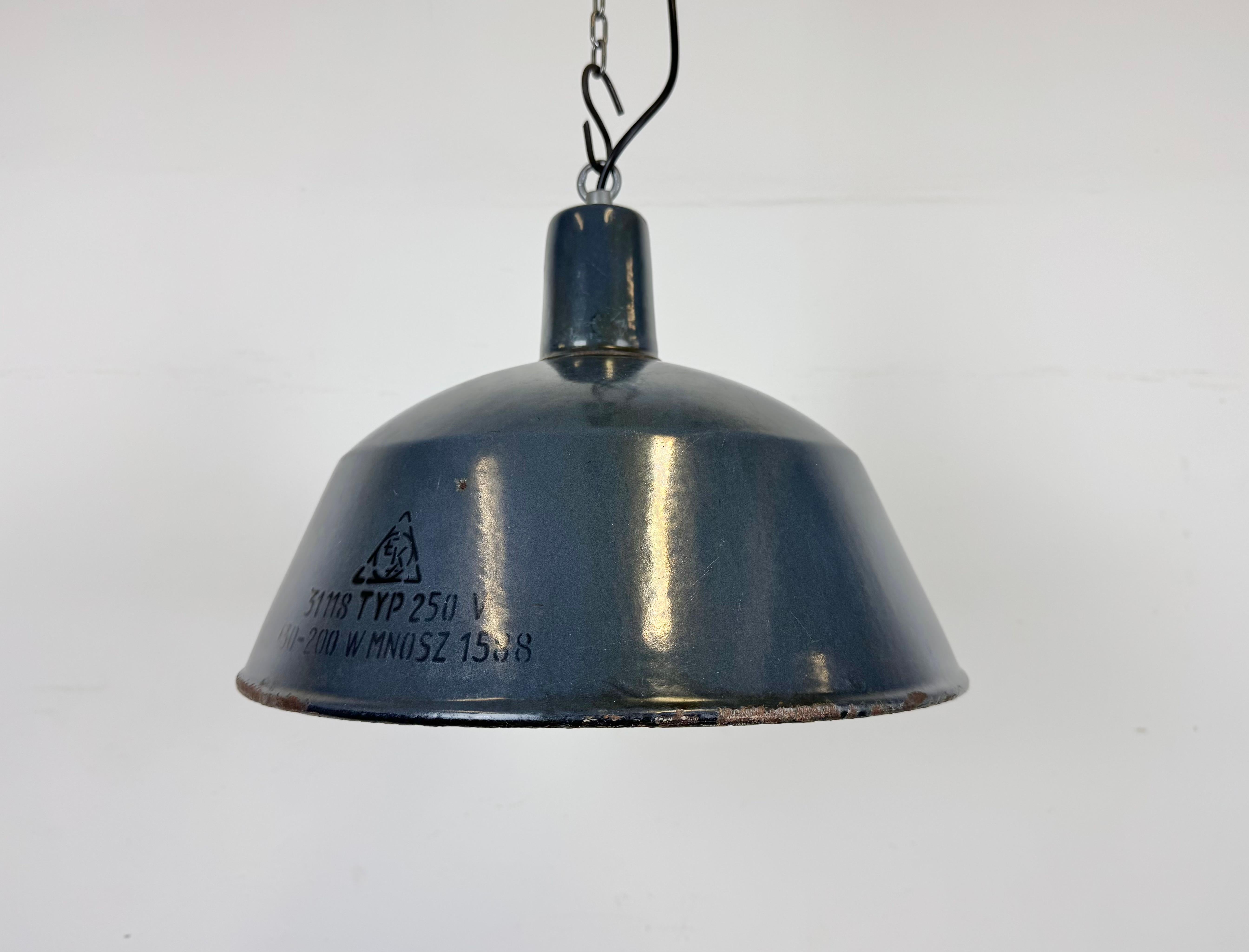 Cette lampe industrielle a été fabriquée par EMAX en Hongrie dans les années 1960. Il se caractérise par un abat-jour en émail bleu foncé, un intérieur en émail blanc et un plateau en fer. La nouvelle douille en porcelaine convient aux ampoules E