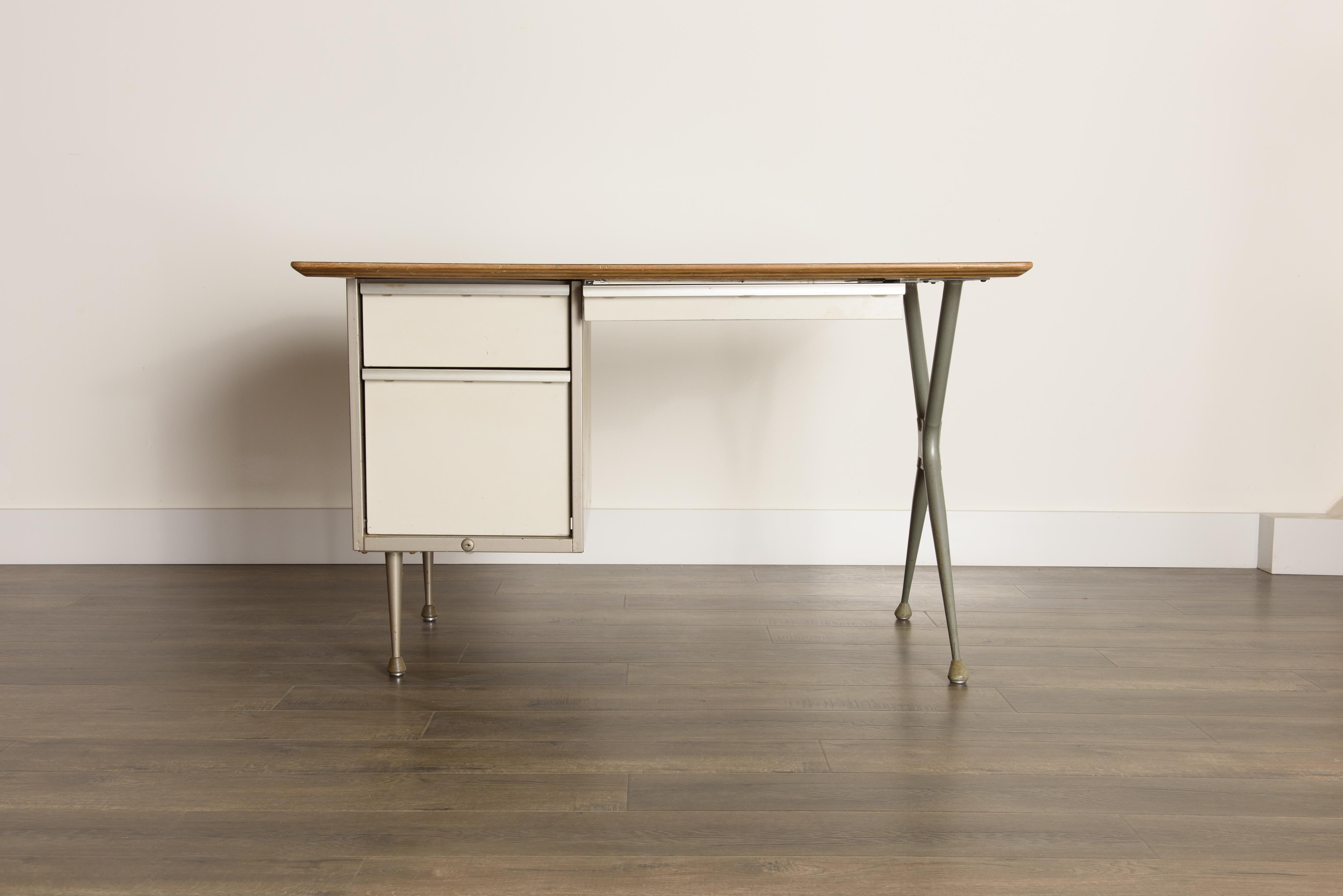 This lovely little Mid-Century Modern industrial desk is by renowned French designer Raymond Loewy and manufactured by Brunswick of Chicago in the 1950s. A collectors piece that would work great in an office, kids room, home office or any