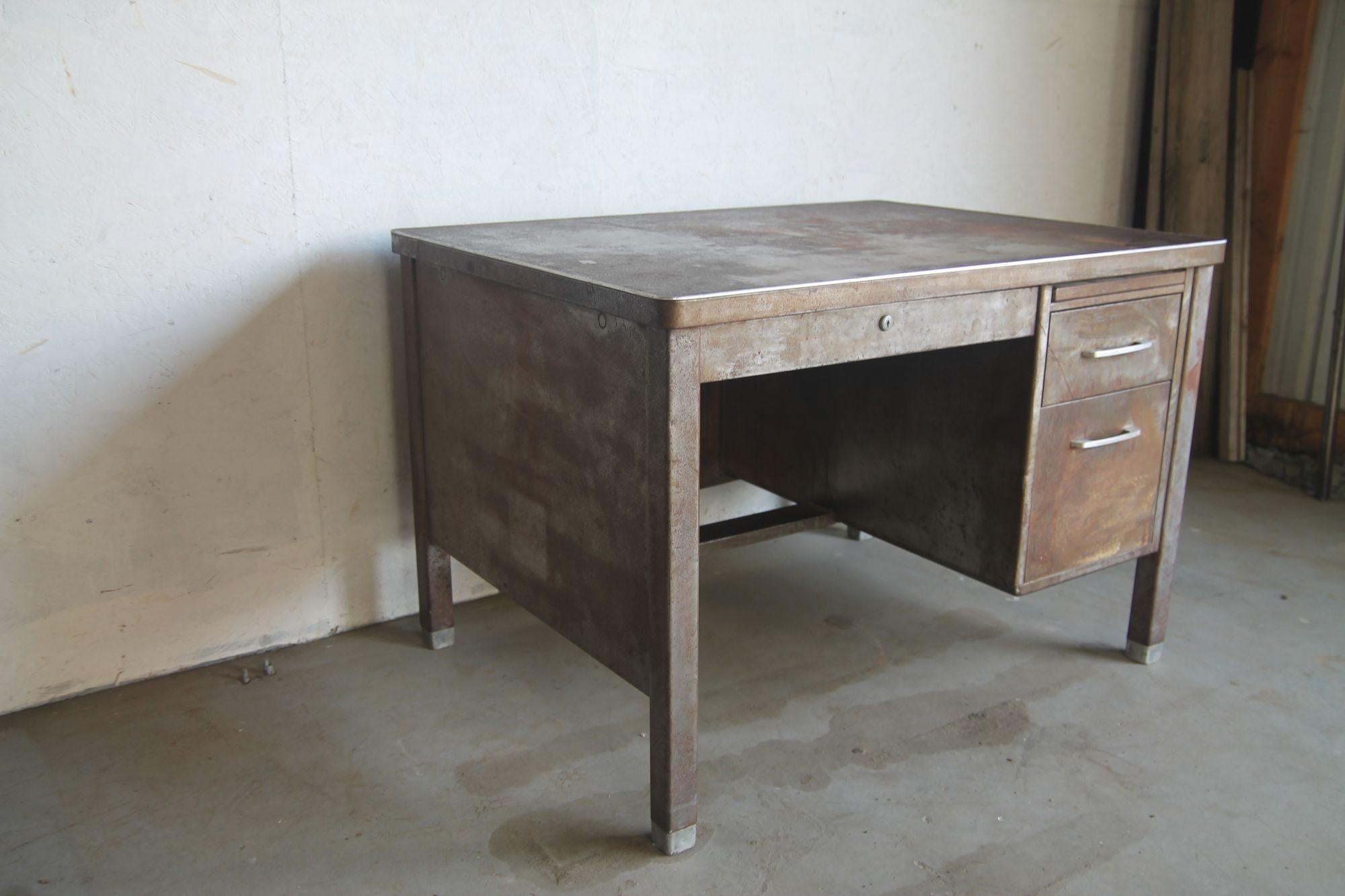 1950's metal industial desk with distressed patina. This desk had been stripped many years ago and over the years has gotten this great distressed patina. I had considered having it refinished but just love the way it looks.