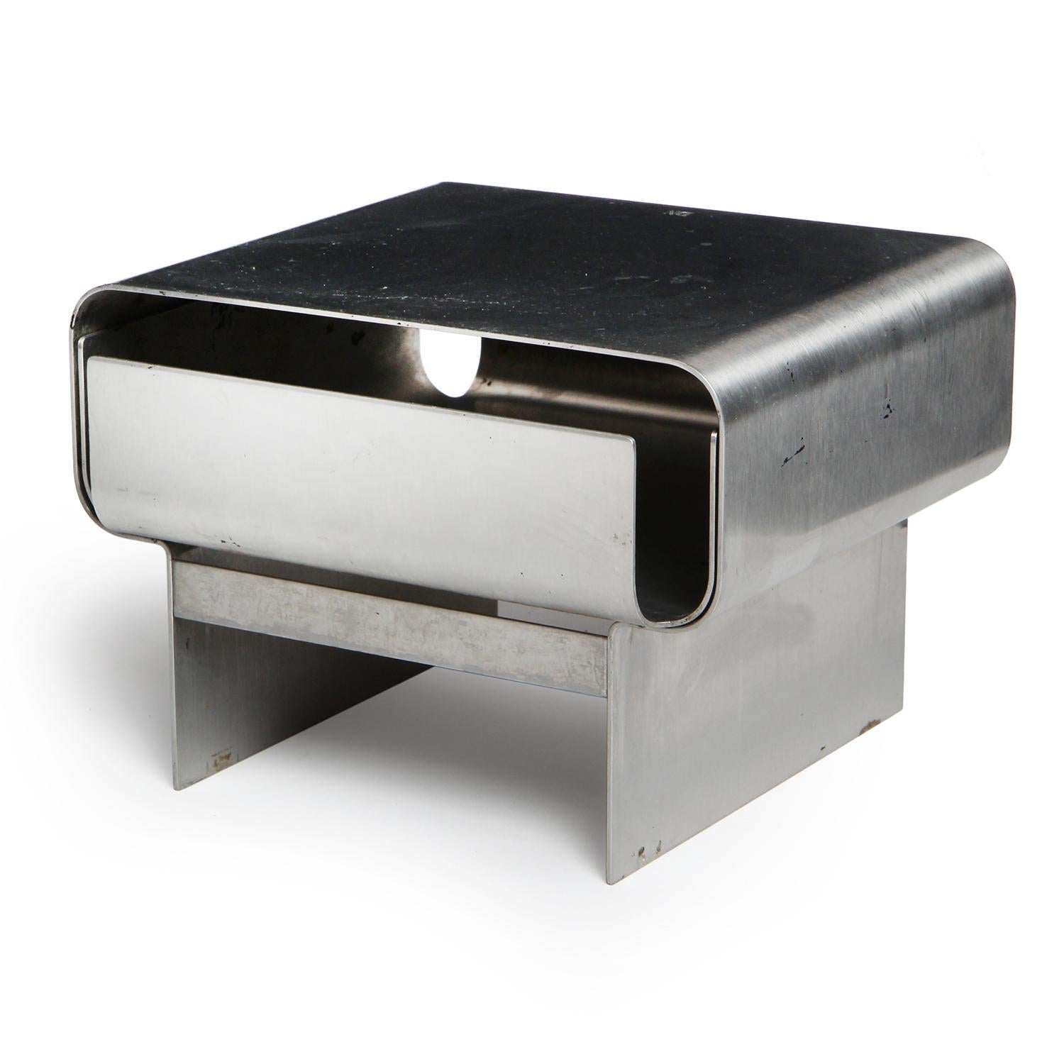 An architectural desktop storage drawer crafted of solid chromed steel. Stamped 