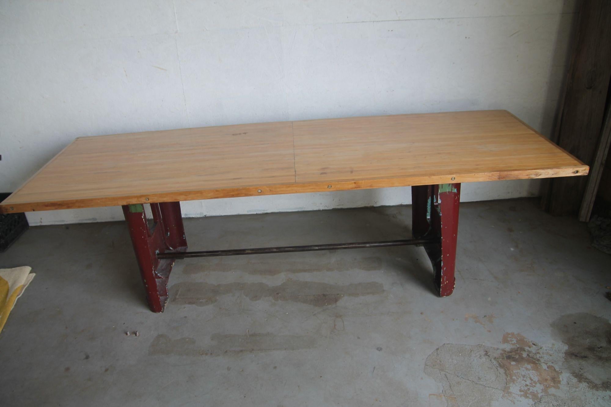 Pleased to offer this great industrial dining table that was recently removed from a NYC loft. Table has a fantasic deco era base that has multi layers of paint over the years. Red now is the prodominate color but you do see signs of yellow and