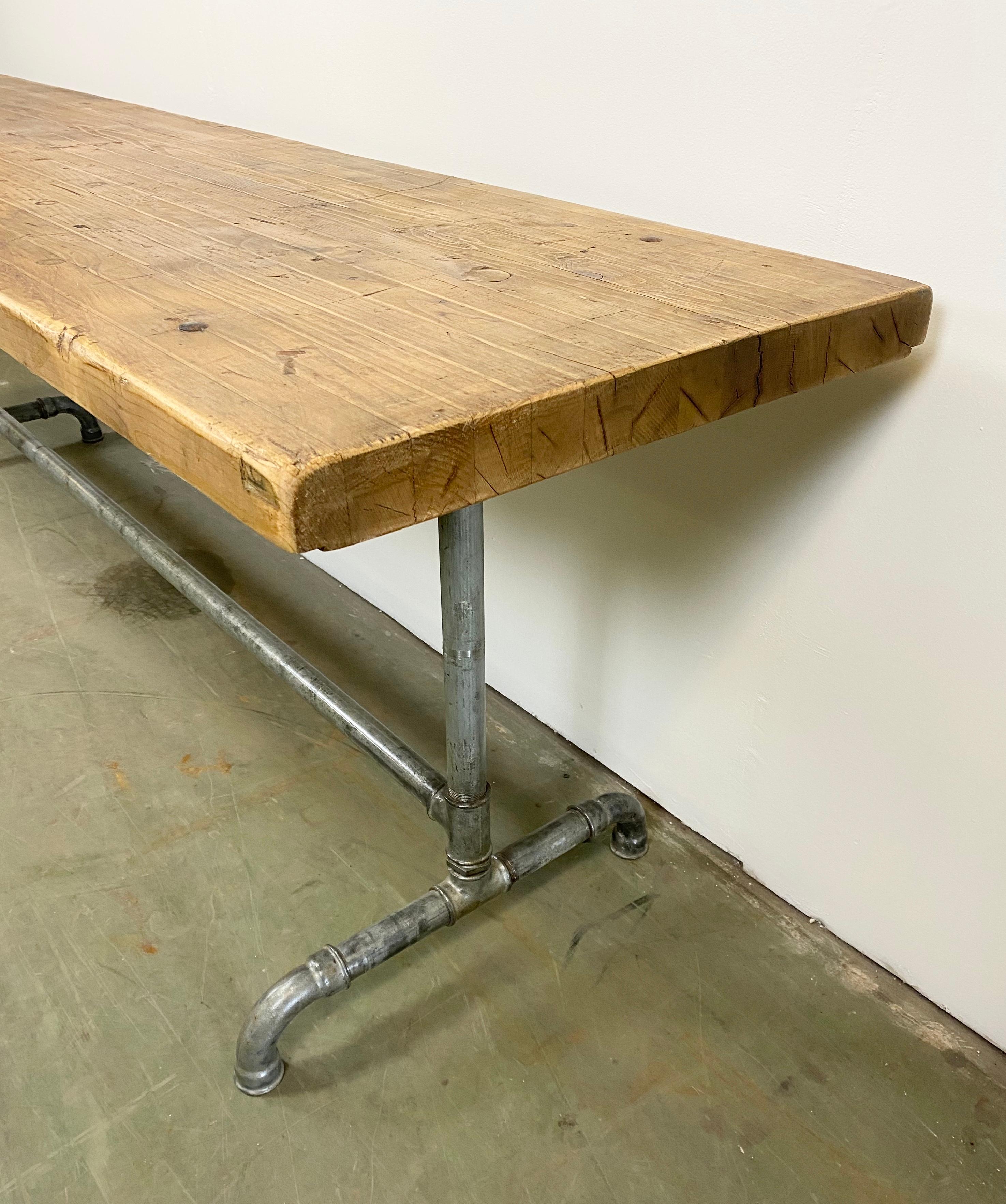 Industrieller Esstisch aus den 1960er Jahren. Die Konstruktion besteht aus Eisenrohren und einer massiven Holzplatte. Das Gewicht des Tisches beträgt 60 kg.