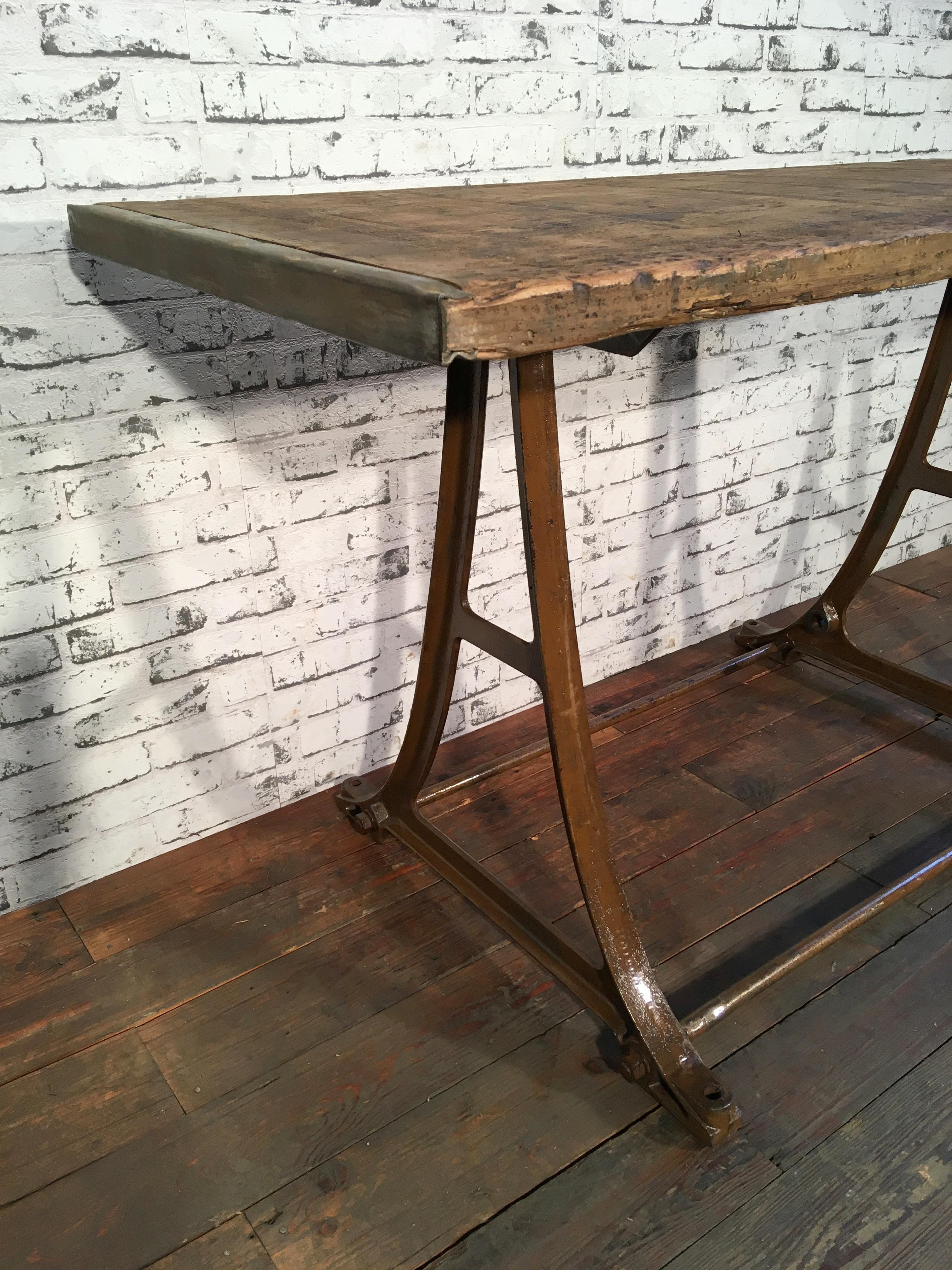 Industrial dining table from the 1960s. It features cast-iron table base and a solid old wooden plate with very nice patina. Weight : 39 kg