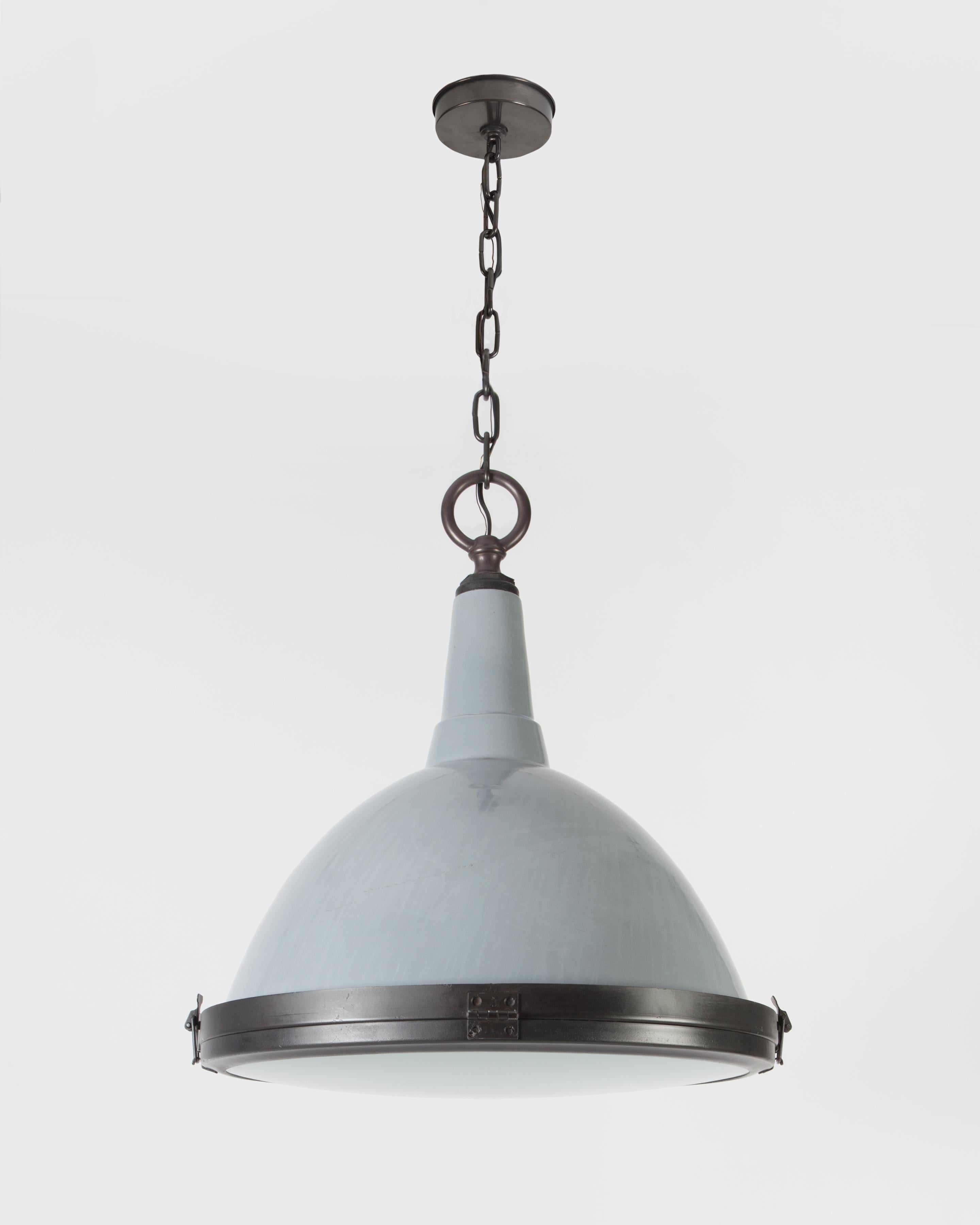 A vintage grey vitreous enameled steel pendant with darkened brass and steel fittings, circa 1950. Having a hinged bottom frame holding a frosted glass lens. Due to the antique nature of this fixture, there may be some nicks or imperfections in the