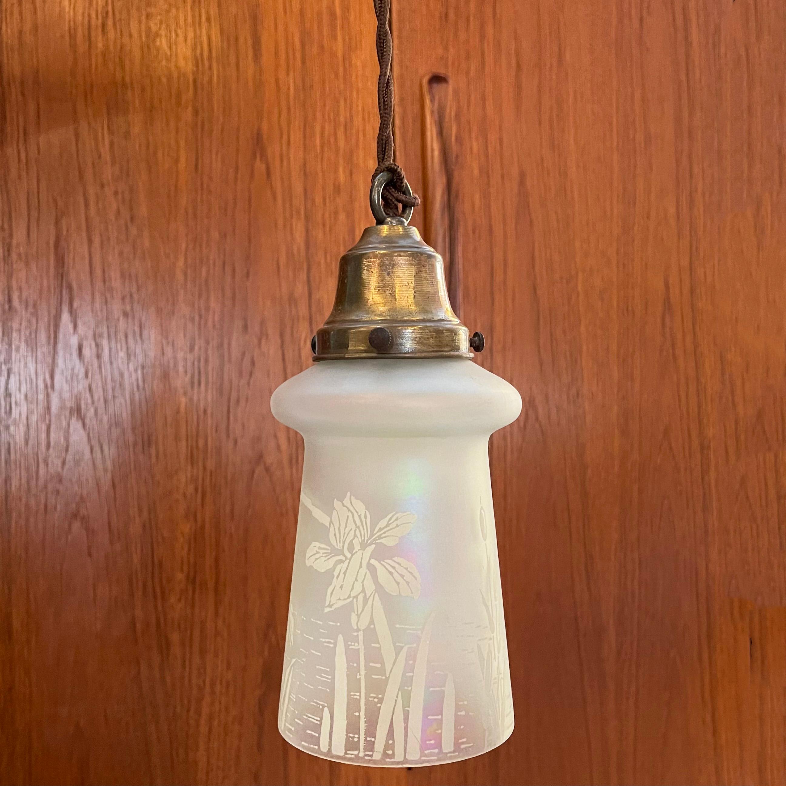 Industrial pendant light features an acid-etched, opaline glass shade with brass fitter on 40 inches of braided cloth cord. The pendant is newly wired to accept up to a 60 watt medium socket bulb.