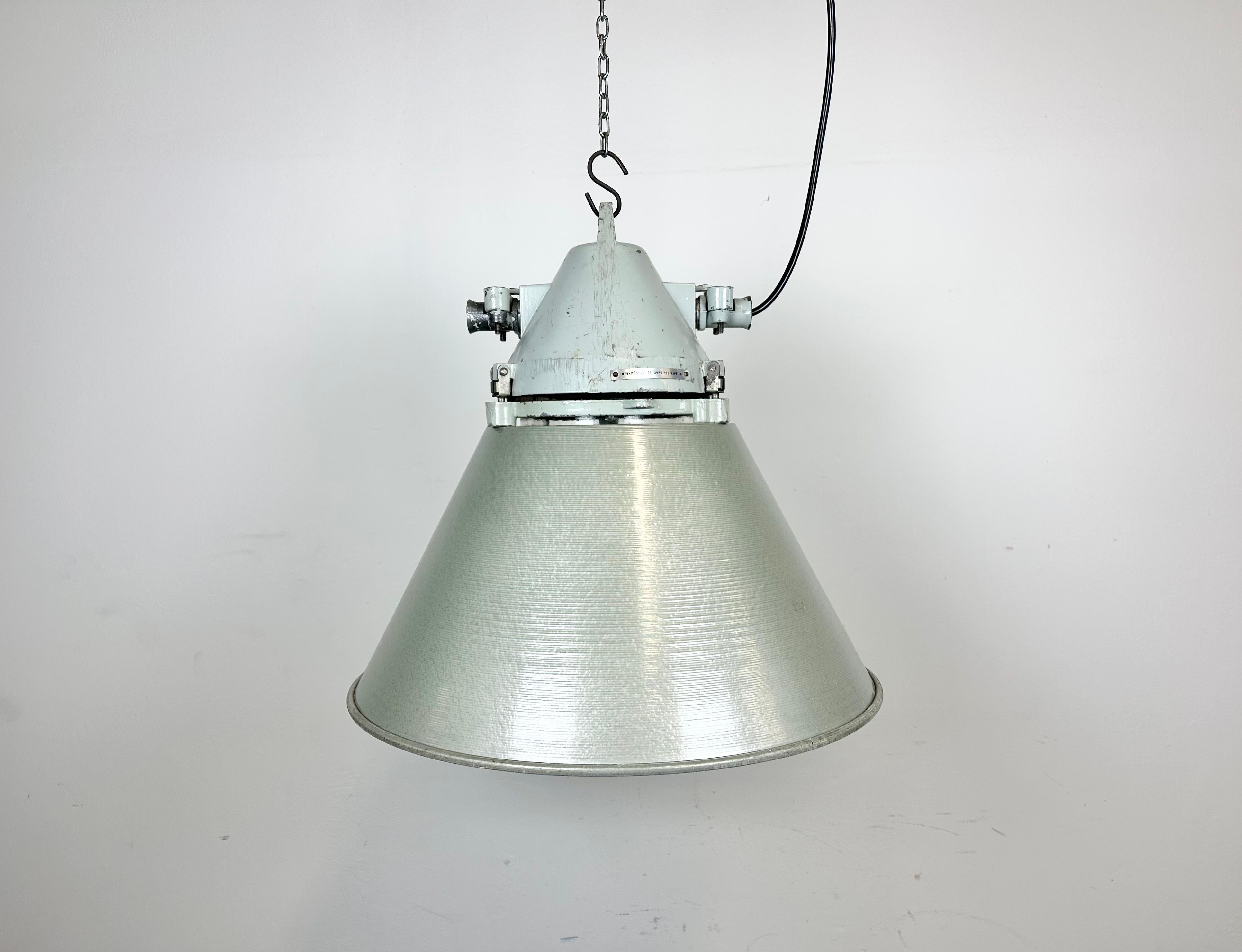 Lampe d'usine industrielle fabriquée par Elektrosvit en ex-Tchécoslovaquie dans les années 1970. Il est composé d'un corps en fonte d'aluminium et d'un abat-jour en verre clair antidéflagrant et en aluminium peint au marteau.
La douille nécessite