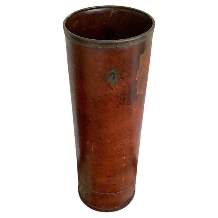 An antique industrial textile factory bin from The Newport Ribbon Textile Mill in Newport Rhode Island, established in 1882; an industrial tube made from either vulcanized fibre or cardboard with tin rim on top and bottom.