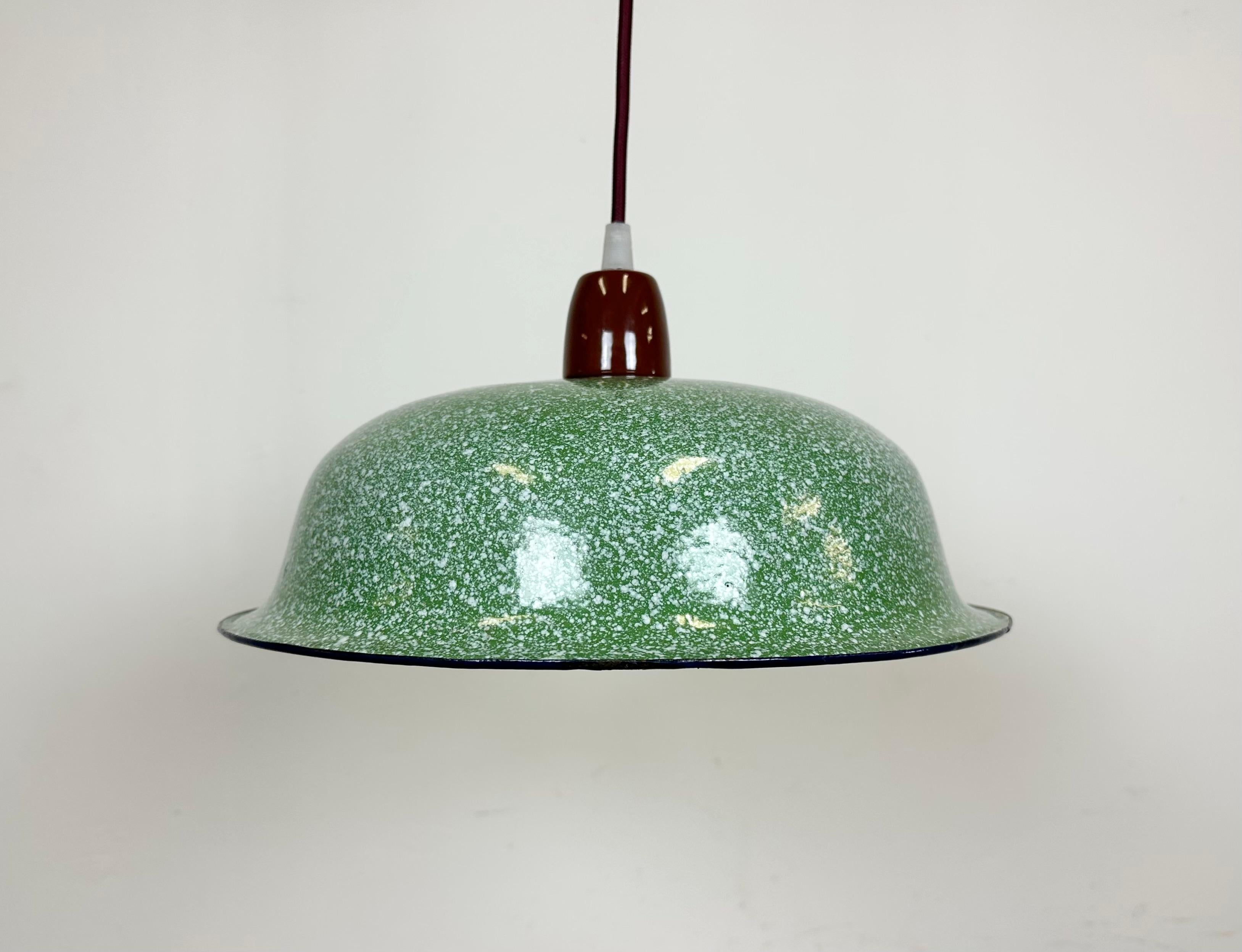 Vintage industrial enamel ceiling lamp made in Portugal during the 1960s. It features a green enamel shade with a green enamel interior and a new brown porcelain socket and ceiling mounting. The socket requires E 27/ E 26 light bulbs. New textile