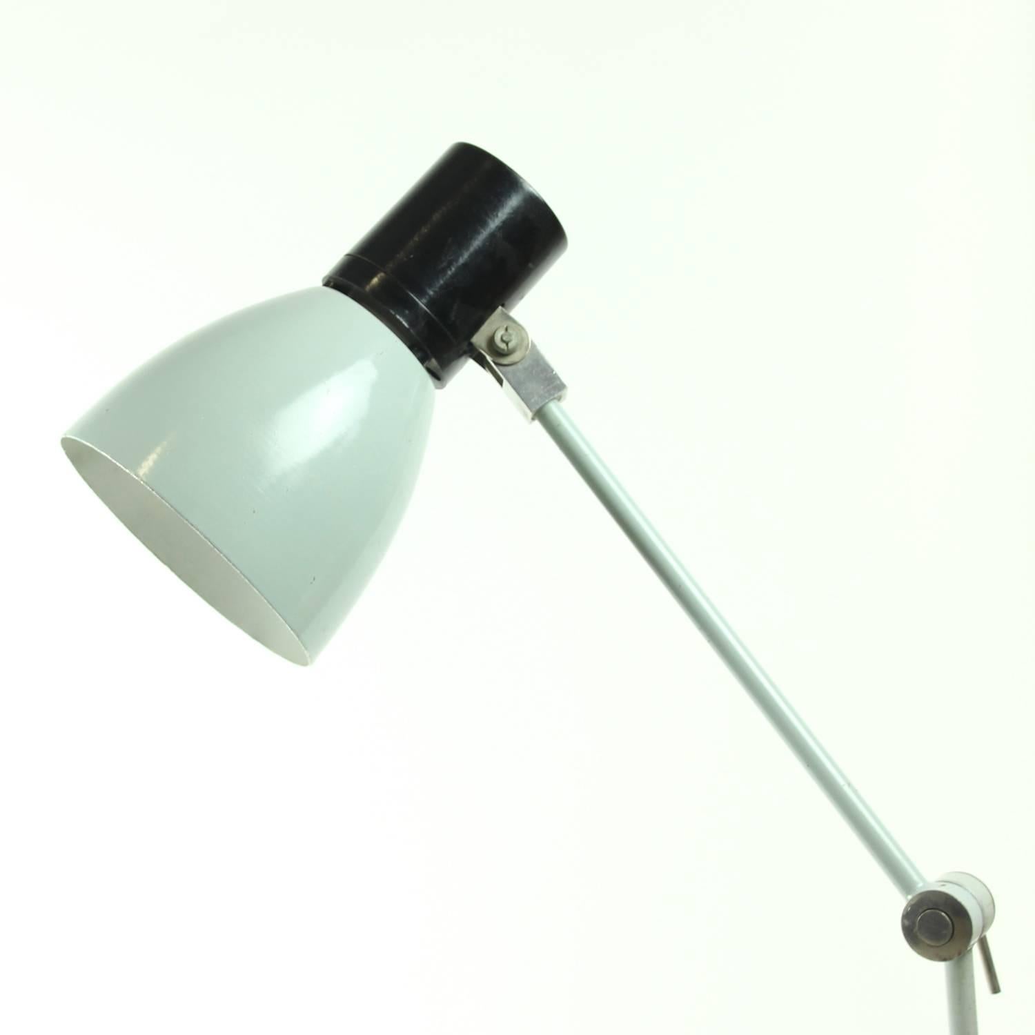 Simple and very functional desk lamp. Originally used as a factory table lighting. Grey lamp, made of metal construction in a very good condition. Easy to fix to any desk by the screw-on system, which is easy to use and leaves more room on the desk.