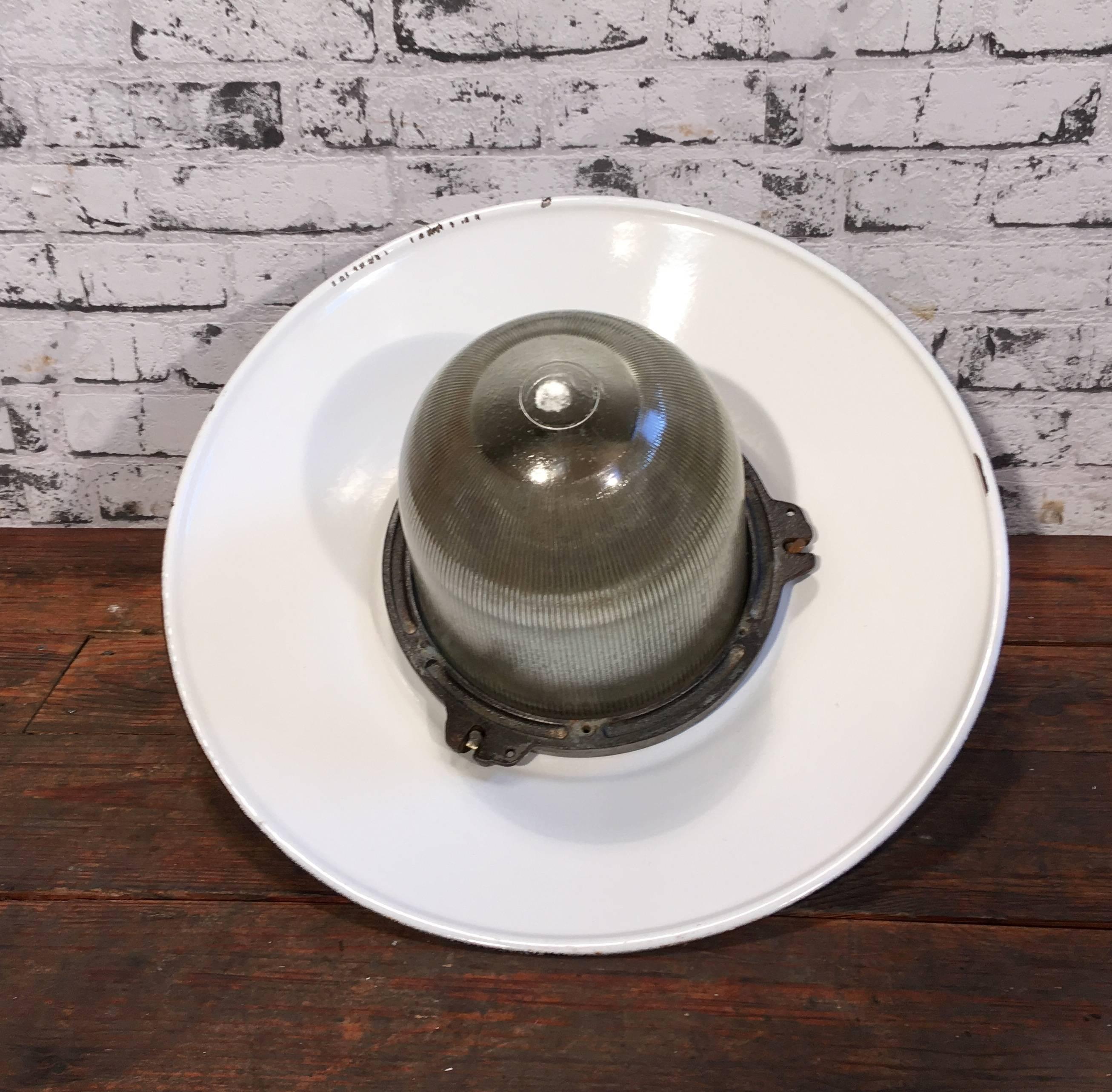 Industrial factory pendant lamp in cast iron. Dark grey metal enamel shade with white interior. Striped glass. Porcelain socket  for E 27 lighbulbs.. New wire. Weight: 6.0 kg.
