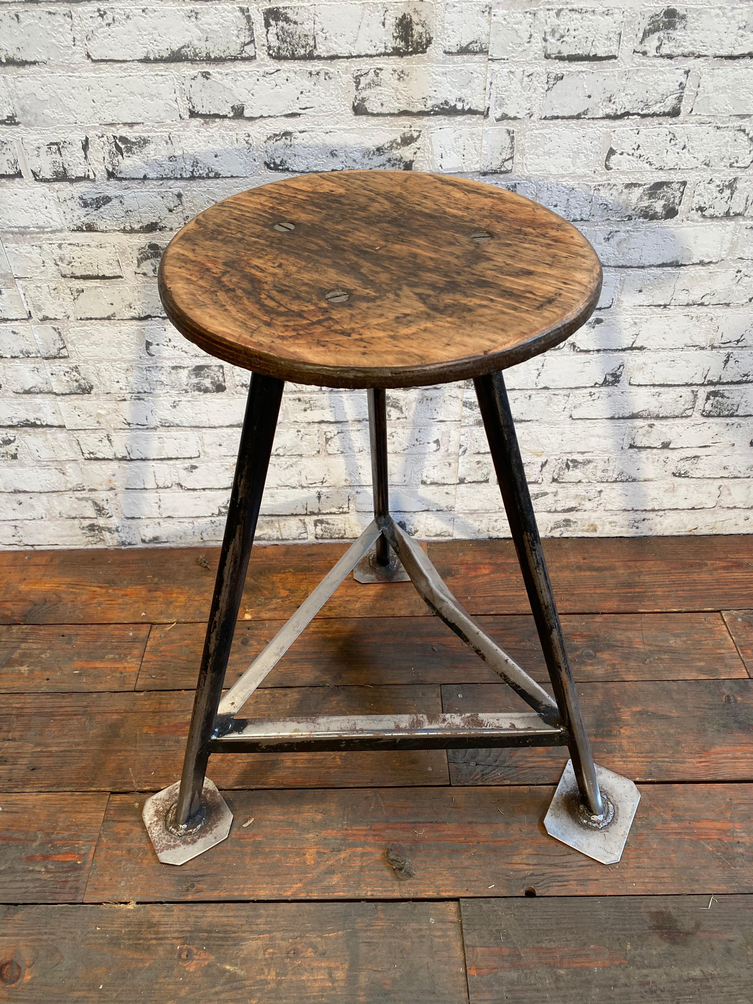Industrial stool with a wooden seat and a black metal frame.
