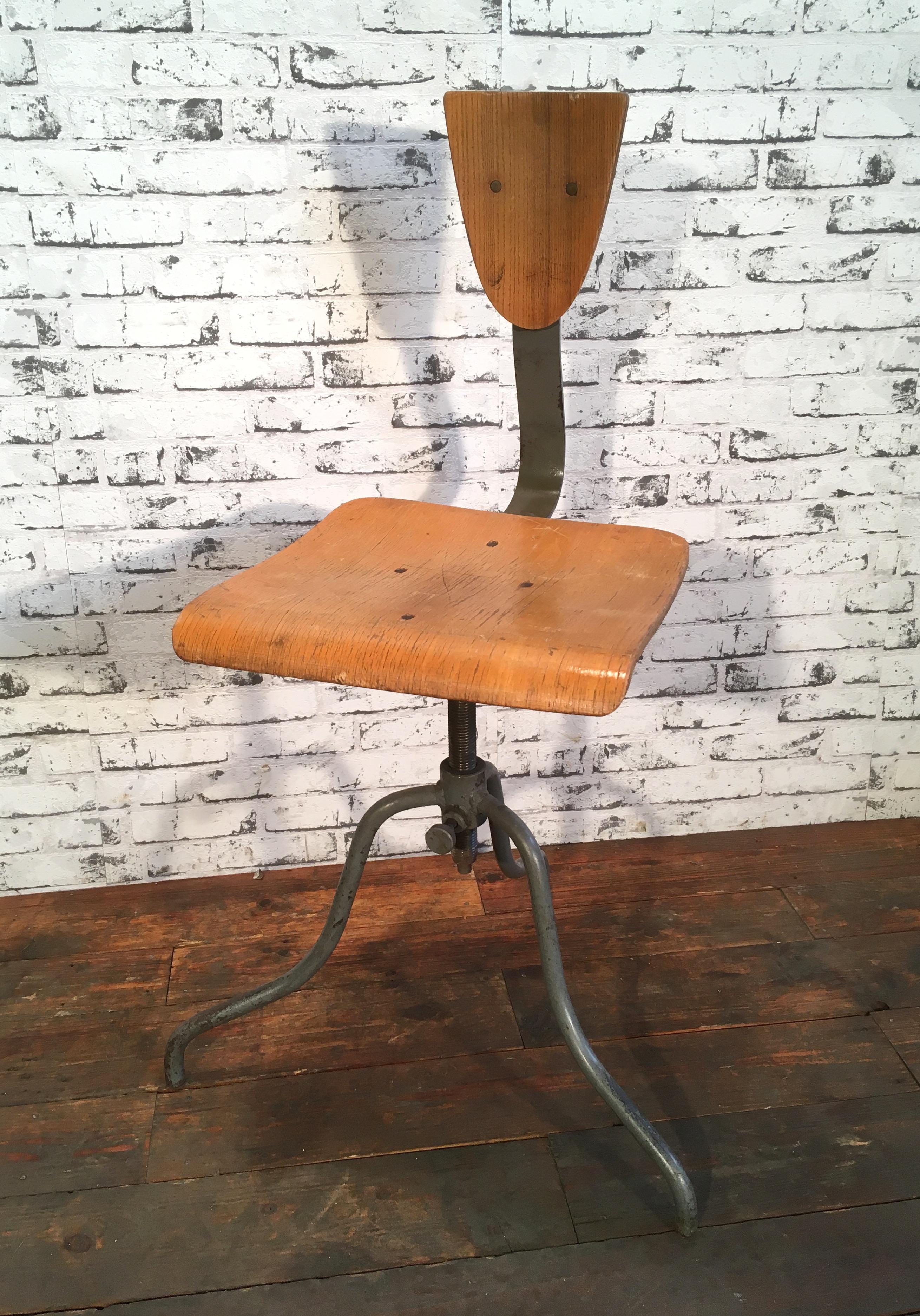 This industrial height adjustable swivel chair was made in former Czechoslovakia during the 1950s. The construction is made of gray painted iron and has a plywood seat and backrest. The chair is in good vintage condition. Weight of the chair is 8