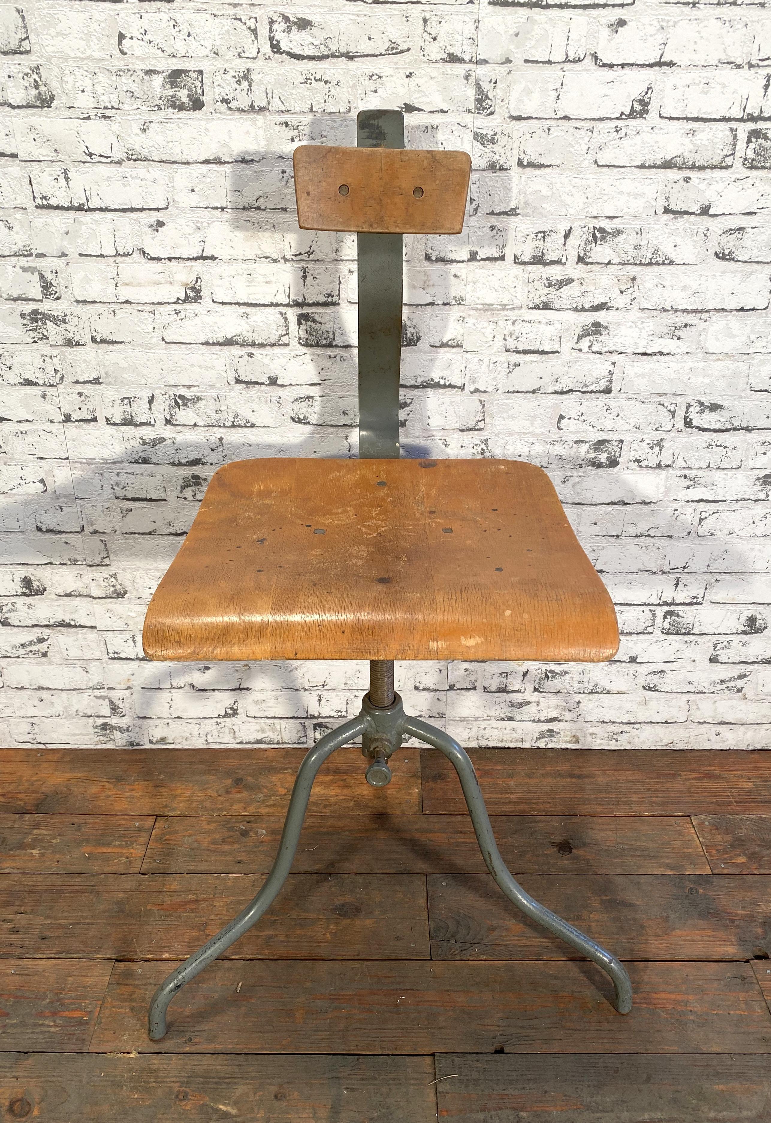 This industrial height adjustable swivel chair was made in former Czechoslovakia during the 1960s. The construction is made of gray painted iron and has a plywood seat and backrest. The chair is in very good vintage condition. Weight of the chair is