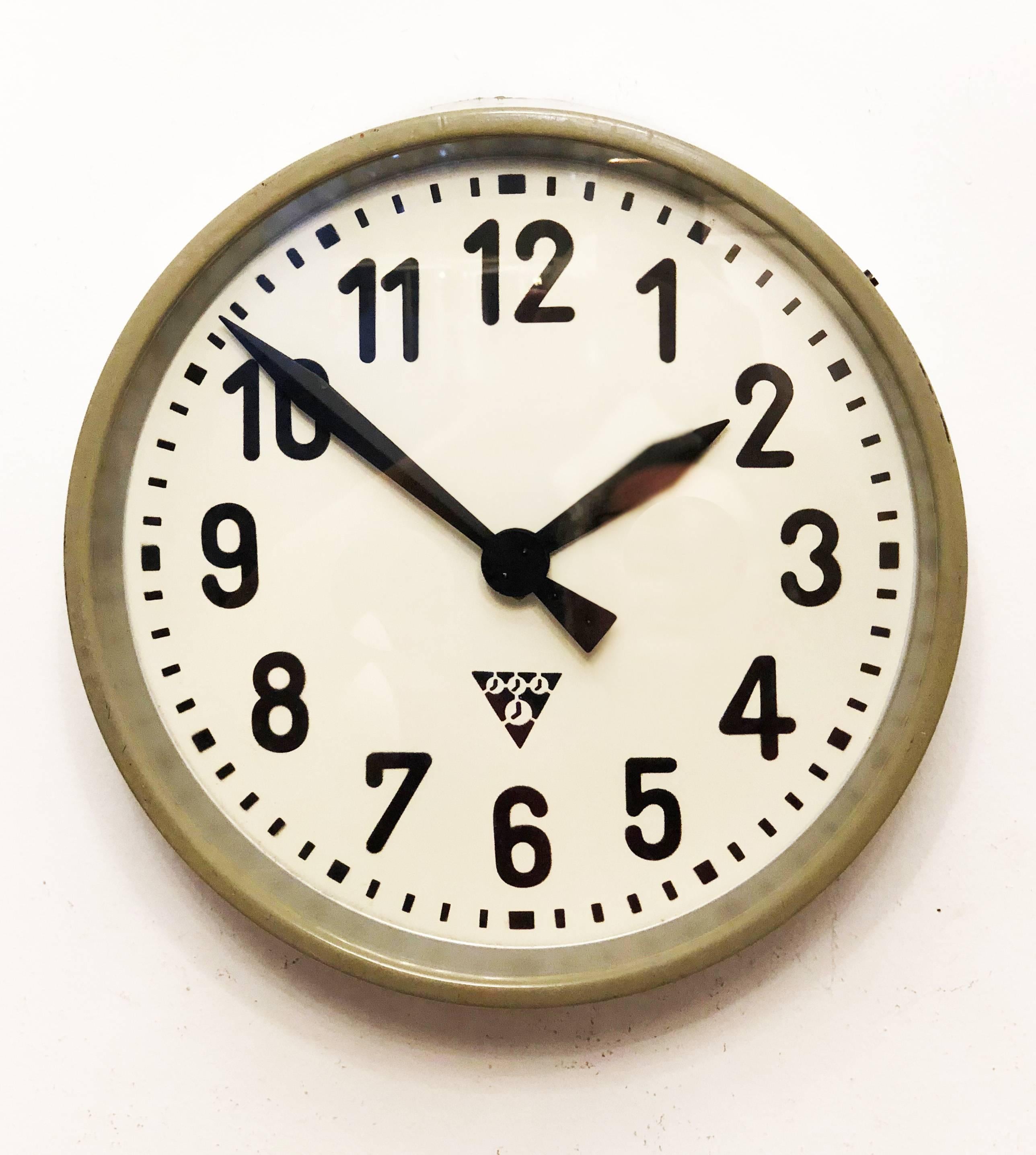 Industrial wall clock Pragotron. Frame made of a painted steel. The clock face is covered with glass. Formerly a slave clock, it is now fitted with a modern quartz movement with an AA-battery.