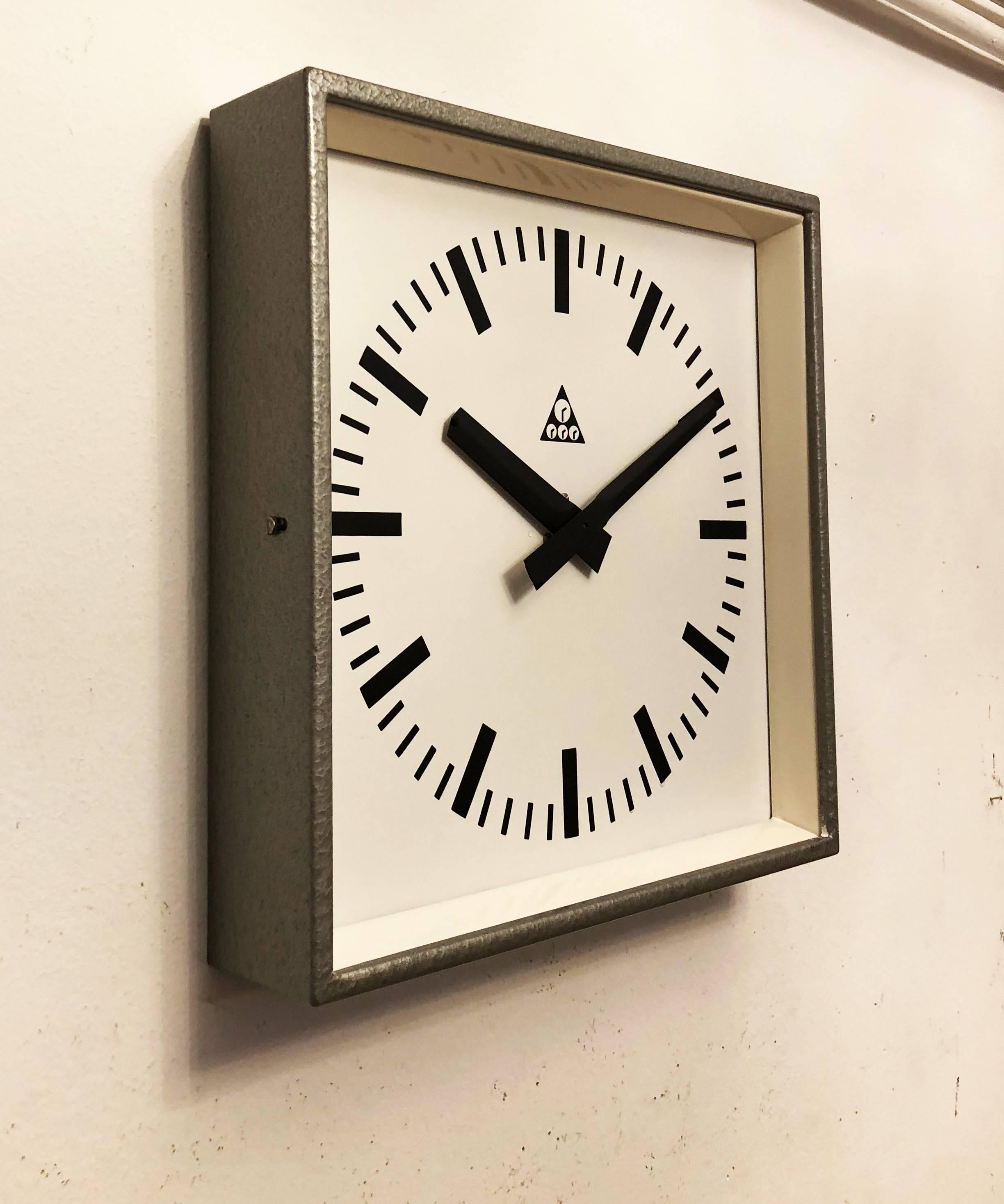 Industrial wall clock Pragotron. Frame made of a painted steel. The clock face is covered with glass. Formerly a slave clock, it is now fitted with a modern quartz movement with an AA-battery.