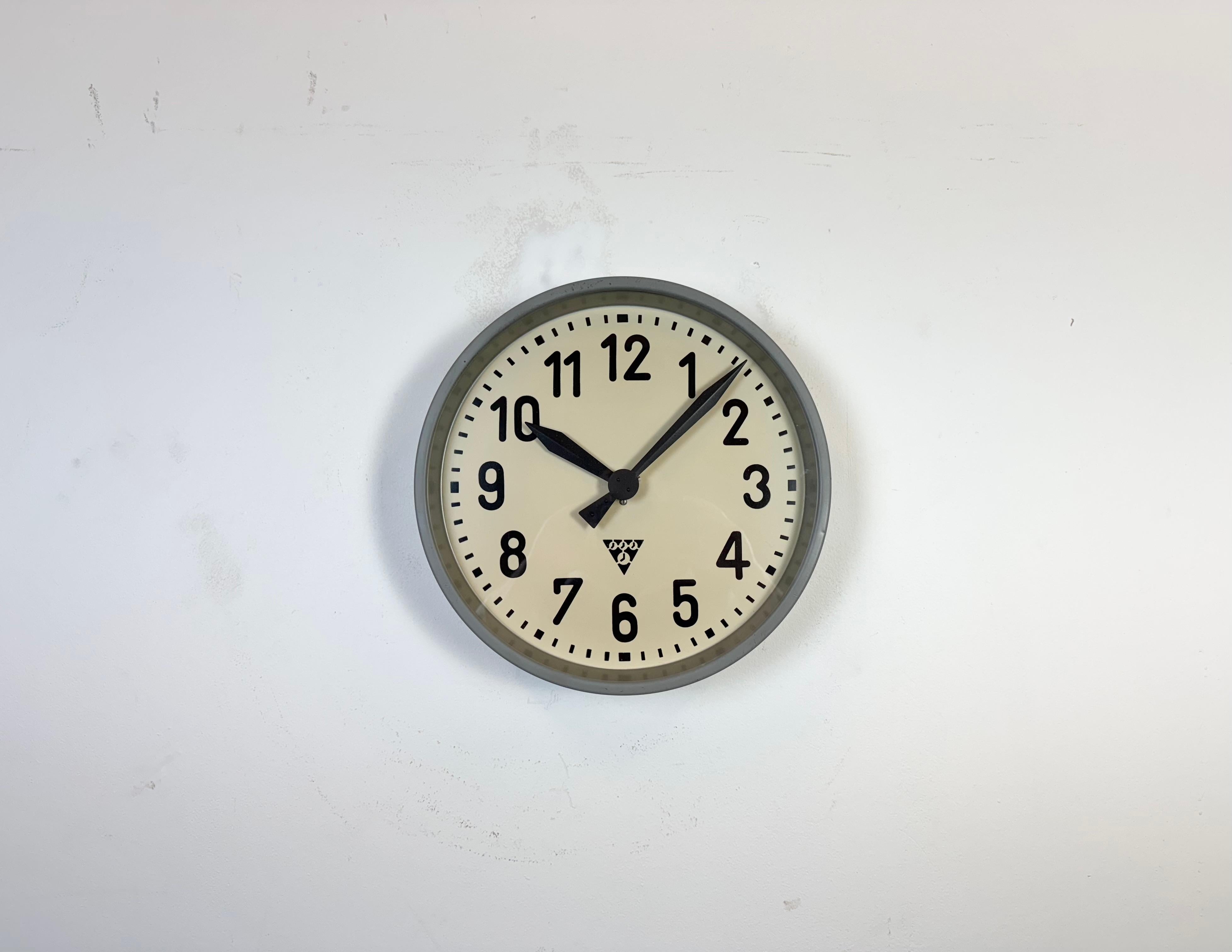 Cette horloge murale a été produite par Pragotron dans l'ancienne Tchécoslovaquie au cours des années 1960. Elle se compose d'un cadre en métal gris, d'un cadran en fer, d'aiguilles en aluminium et d'un couvercle en verre transparent. La pièce a été