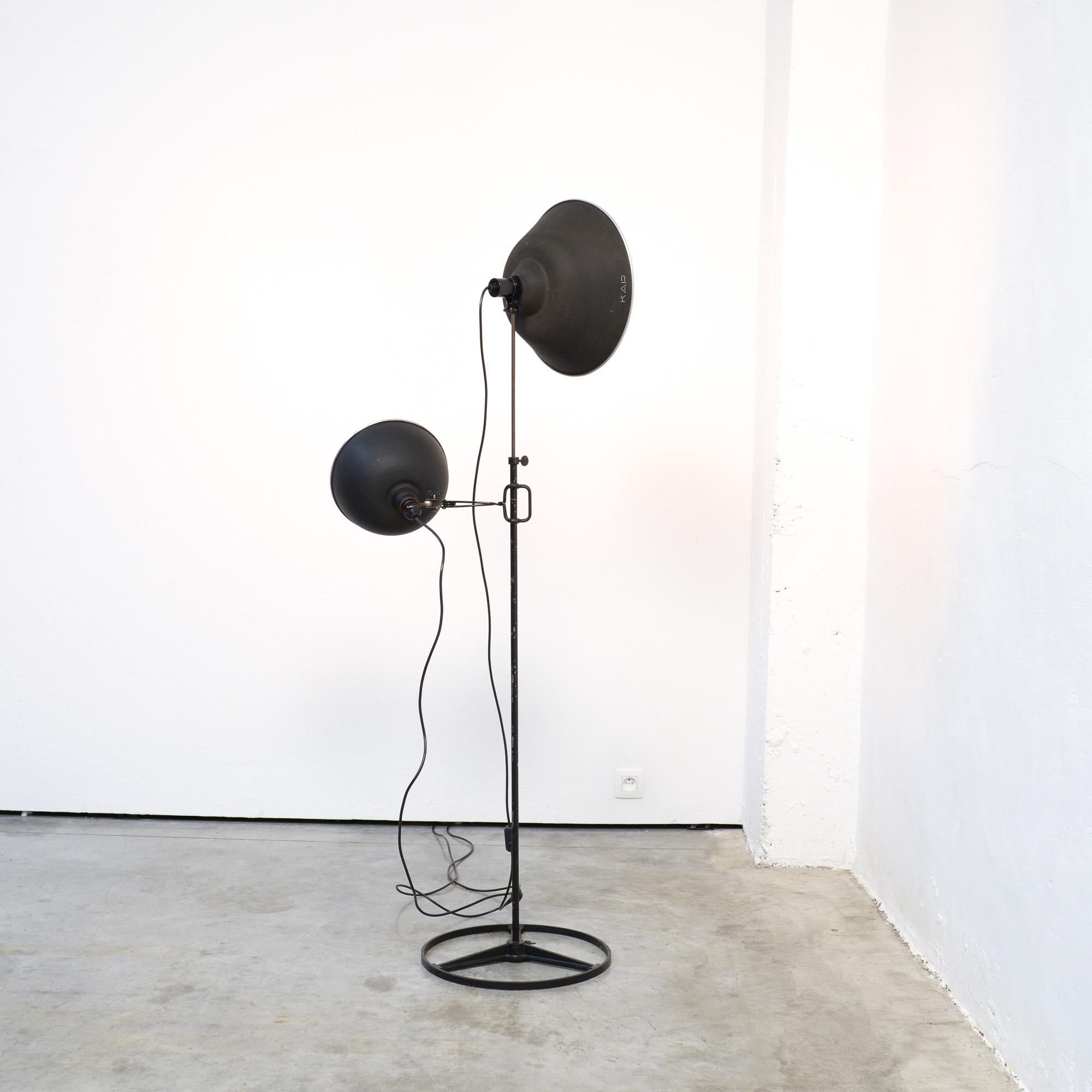 This industrial metal studio lamp was manufactured by KAP in the 1950s. The stem is adjustable in height and the lampshade can be turned. There is a separate clip lamp that can be put on the black stem. The shades have a diameter of 37 cm and 26