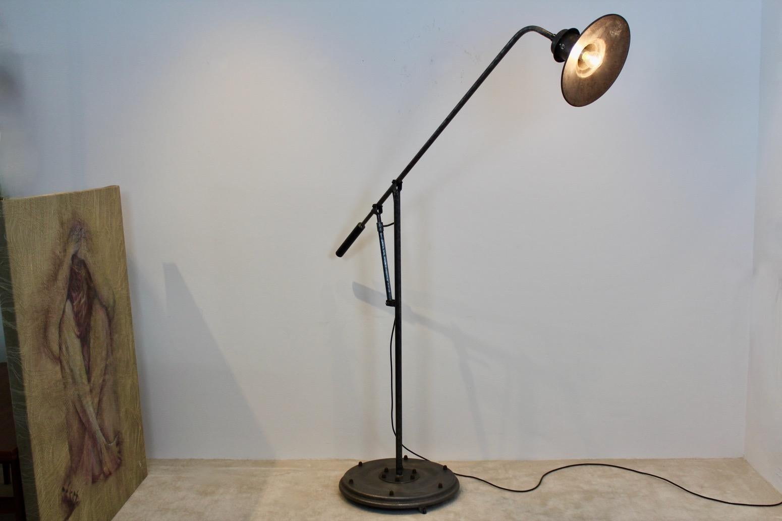Beautiful Industrial lamp with raw charisma and beautiful details. This unique light consists of a totally steel shade, frame and solid base. The base is on efficient wheels, the lamp is partly adjustable in height (110-210) with an 'arm'. Unique