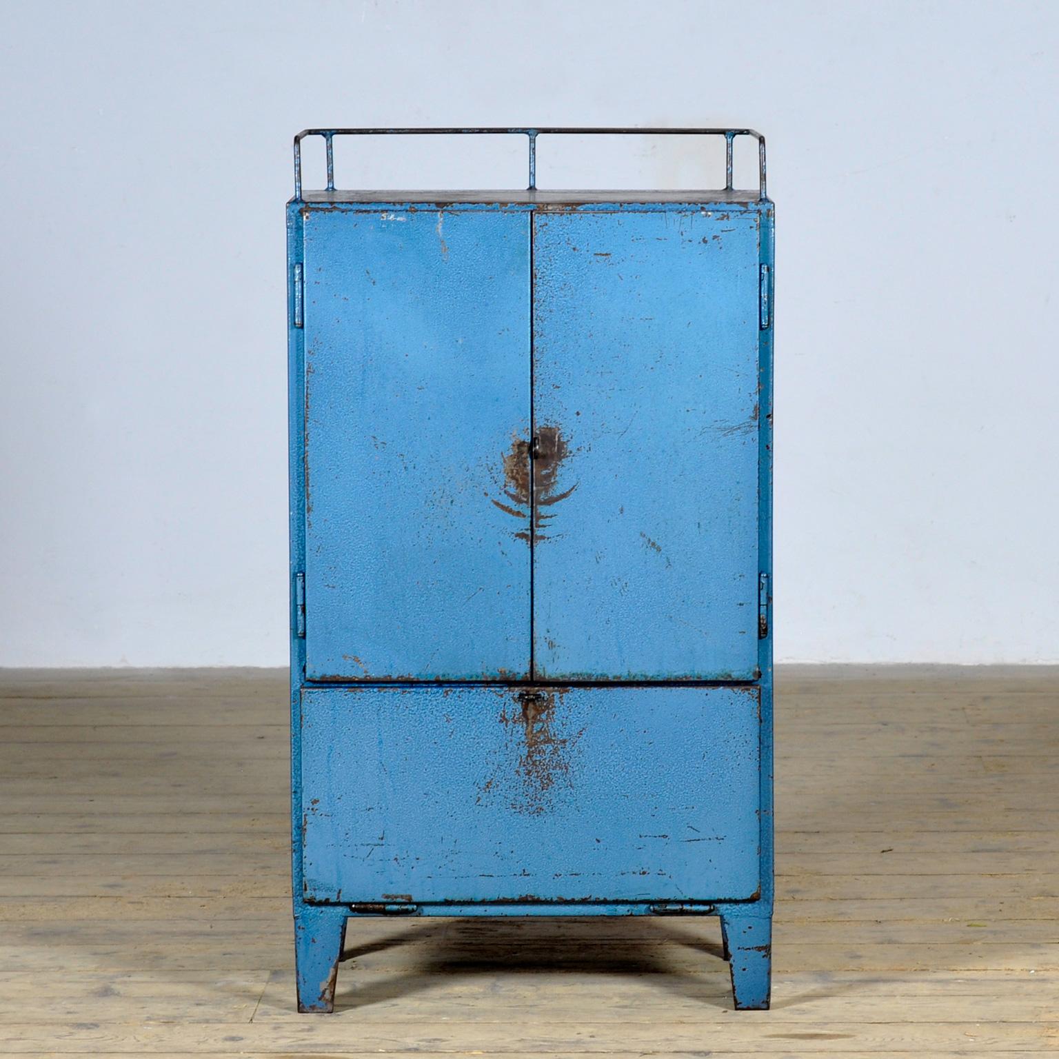 Bring a touch of vintage industry to your interior with this robust 1970s cabinet. Made of iron and finished in a blue hue with authentic signs of wear, this piece exudes character and history. The cabinet features four practical drawers, a spacious