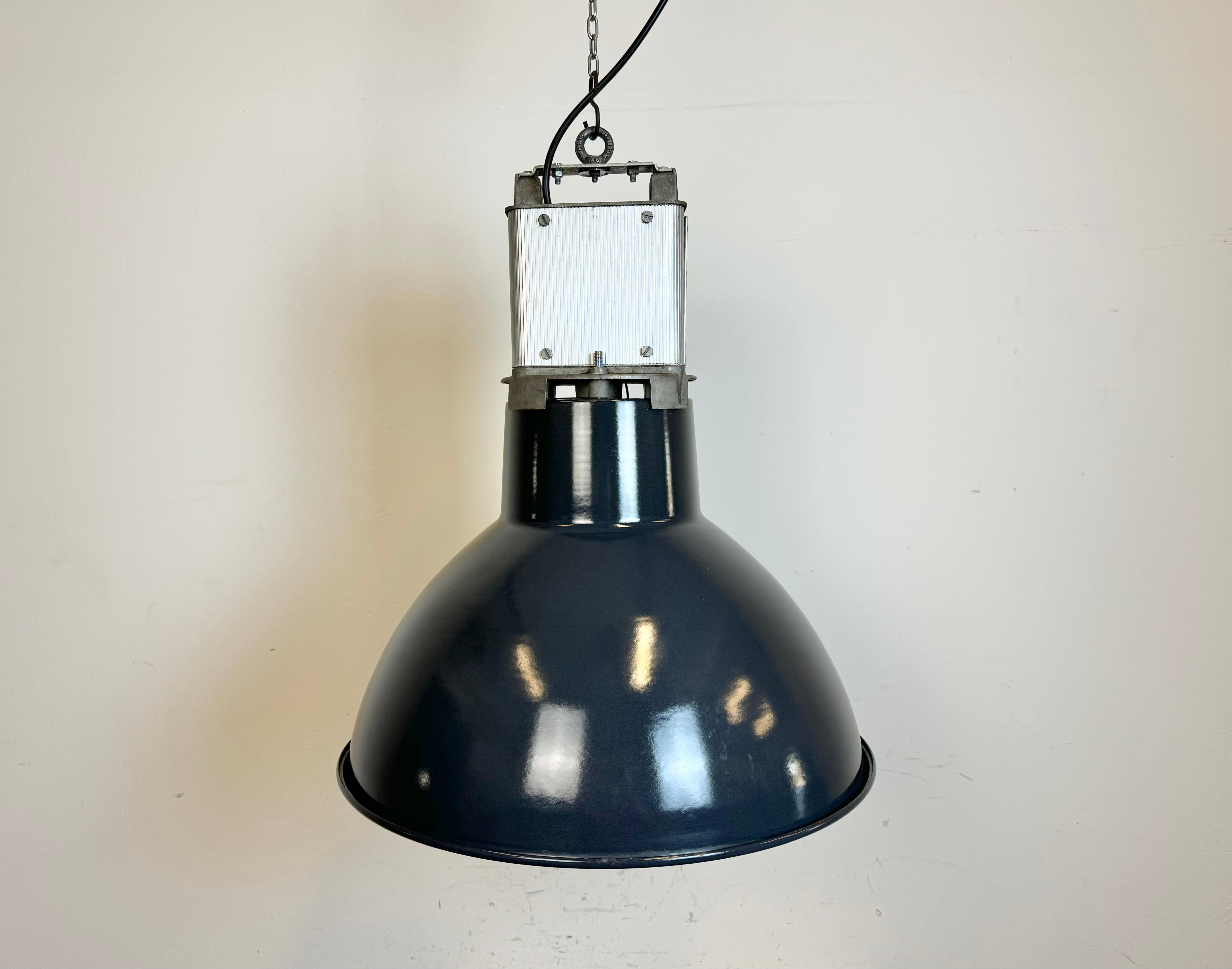 This industrial lamp was made by MAZDA in France during the 1960s. It features a dark blue enamel shade with white enamel interior and metal top. New porcelain socket requires standard E 27/ E26 light bulbs. New wire. The weight of the lamp is 4