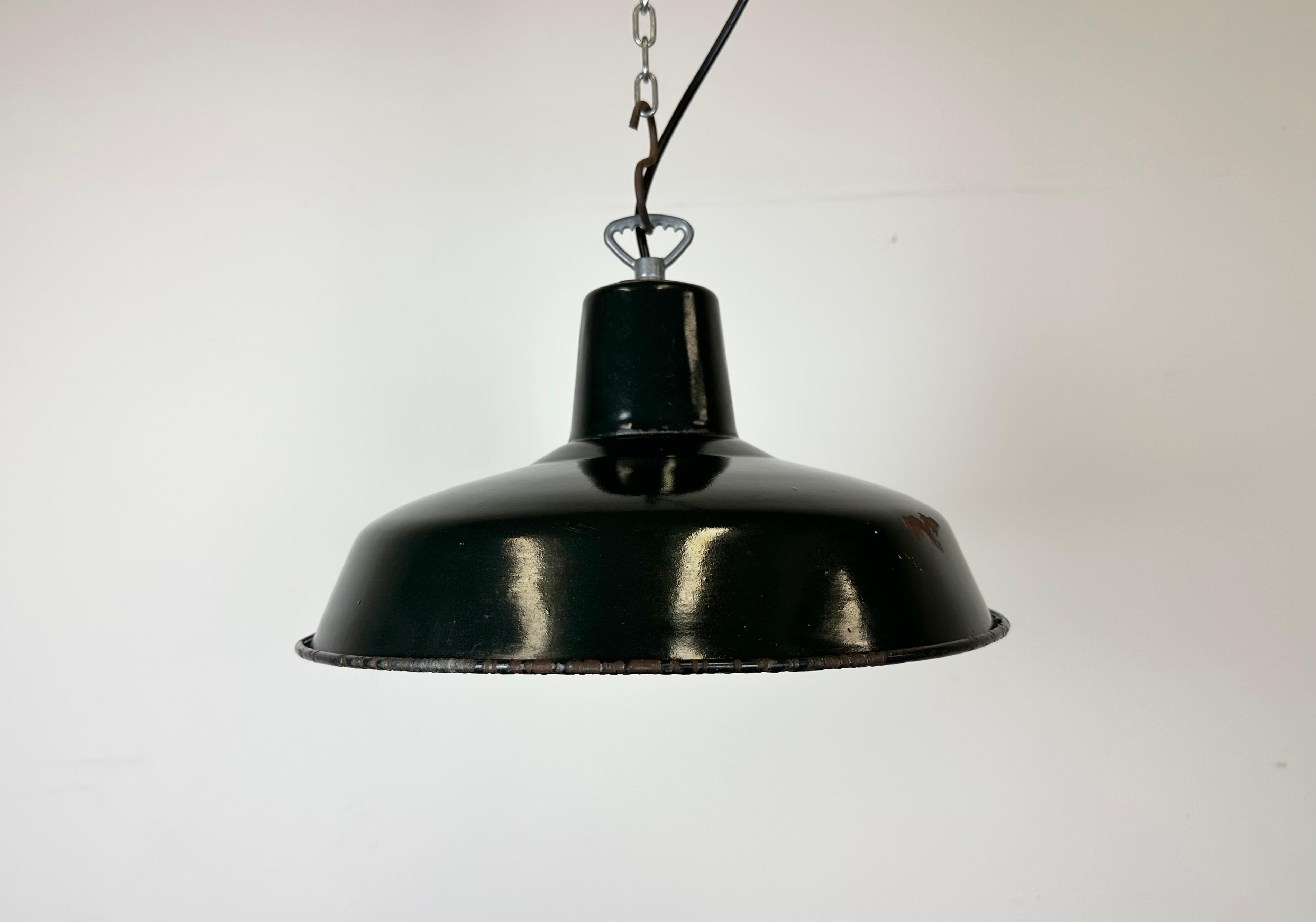 Industrial dark green enamel factory pendant light made in France during the 1960s. White enamel inside the shade. Iron top. The socket requires standard E 27/ E26 light bulbs. New wire. Fully functional. The weight of the lamp is  1 kg.The diameter