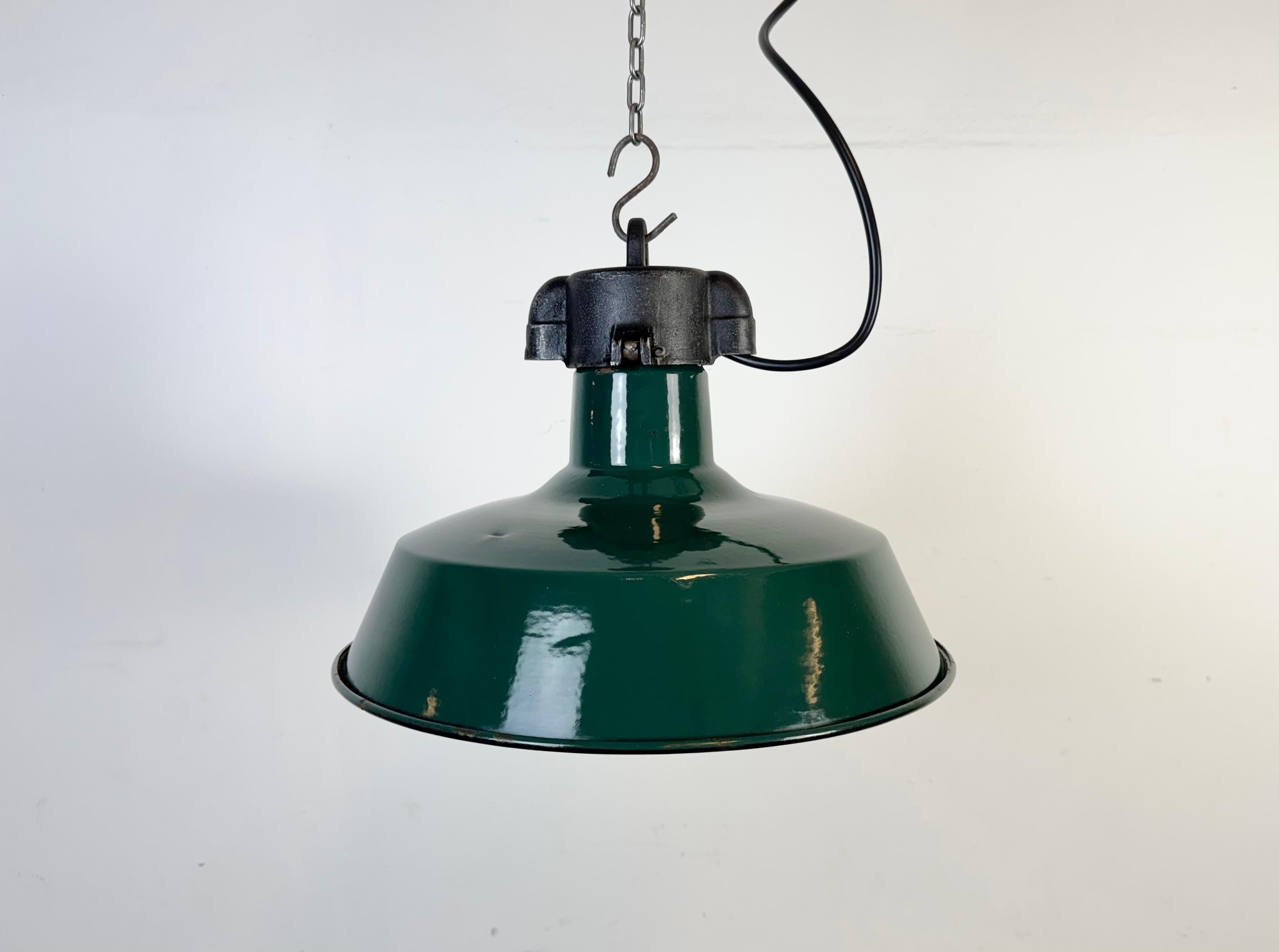 Lampada a sospensione industriale in smalto verde scuro realizzata in Francia negli anni Sessanta. Smalto bianco all'interno del paralume. Piano in ghisa. L'attacco richiede lampadine standard E27/E26. Un nuovo cavo. Il peso della lampada è di 1,7
