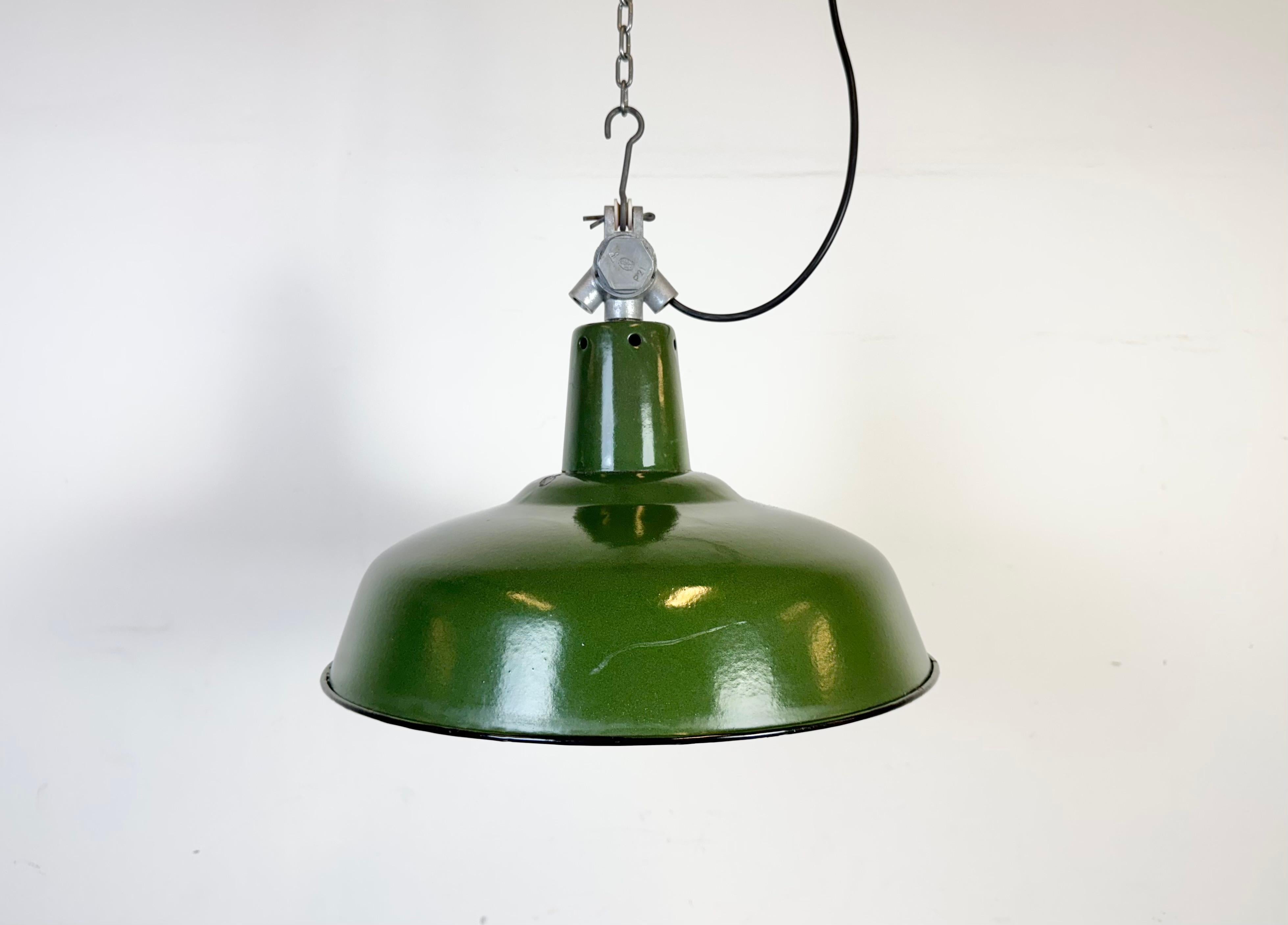 Lampada a sospensione industriale in smalto verde realizzata in Francia negli anni '60. Smalto bianco all'interno del paralume. Piano in alluminio fuso. L'attacco richiede lampadine standard E27/E26. Un nuovo cavo. Il peso della lampada è di 1 kg.