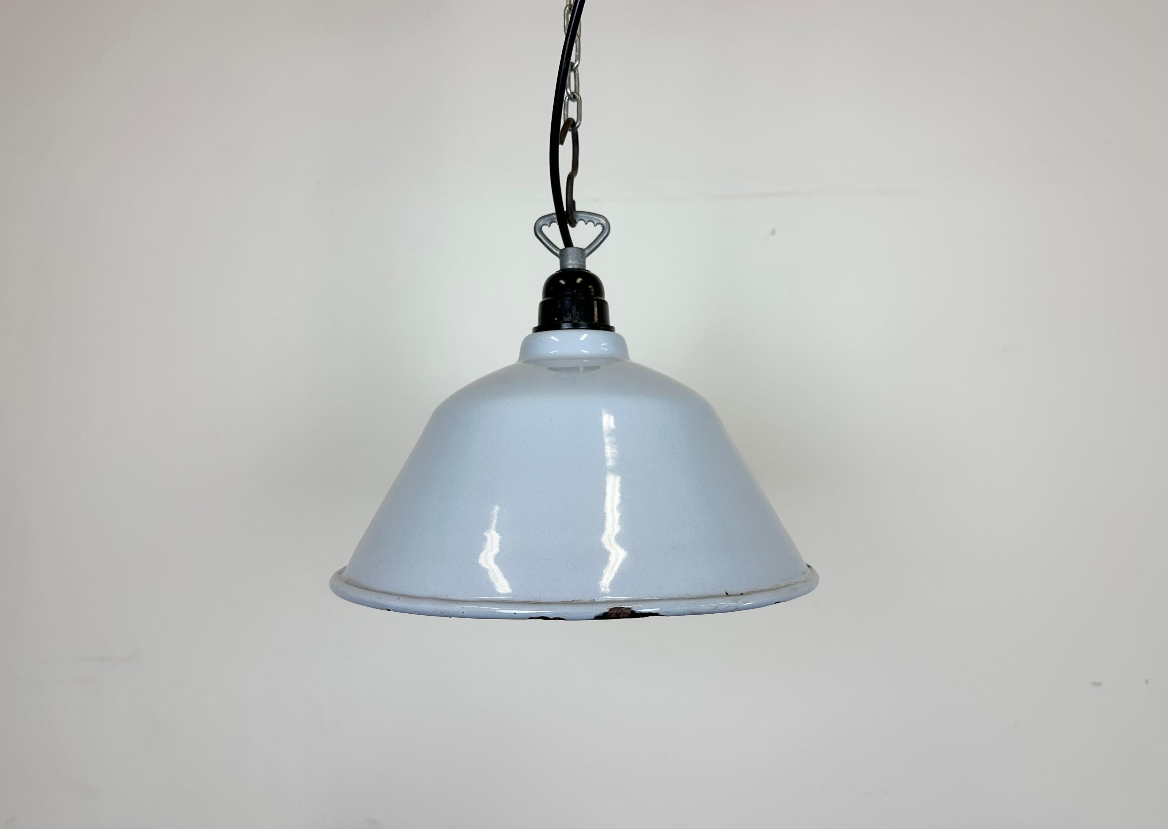 Industrial light grey enamel factory pendant light made in France during the 1960s. White enamel inside the shade. The bakelite socket with iron hook requires standard E 27/ E26 light bulbs. New wire. Fully functional. The weight of the lamp is  0,5
