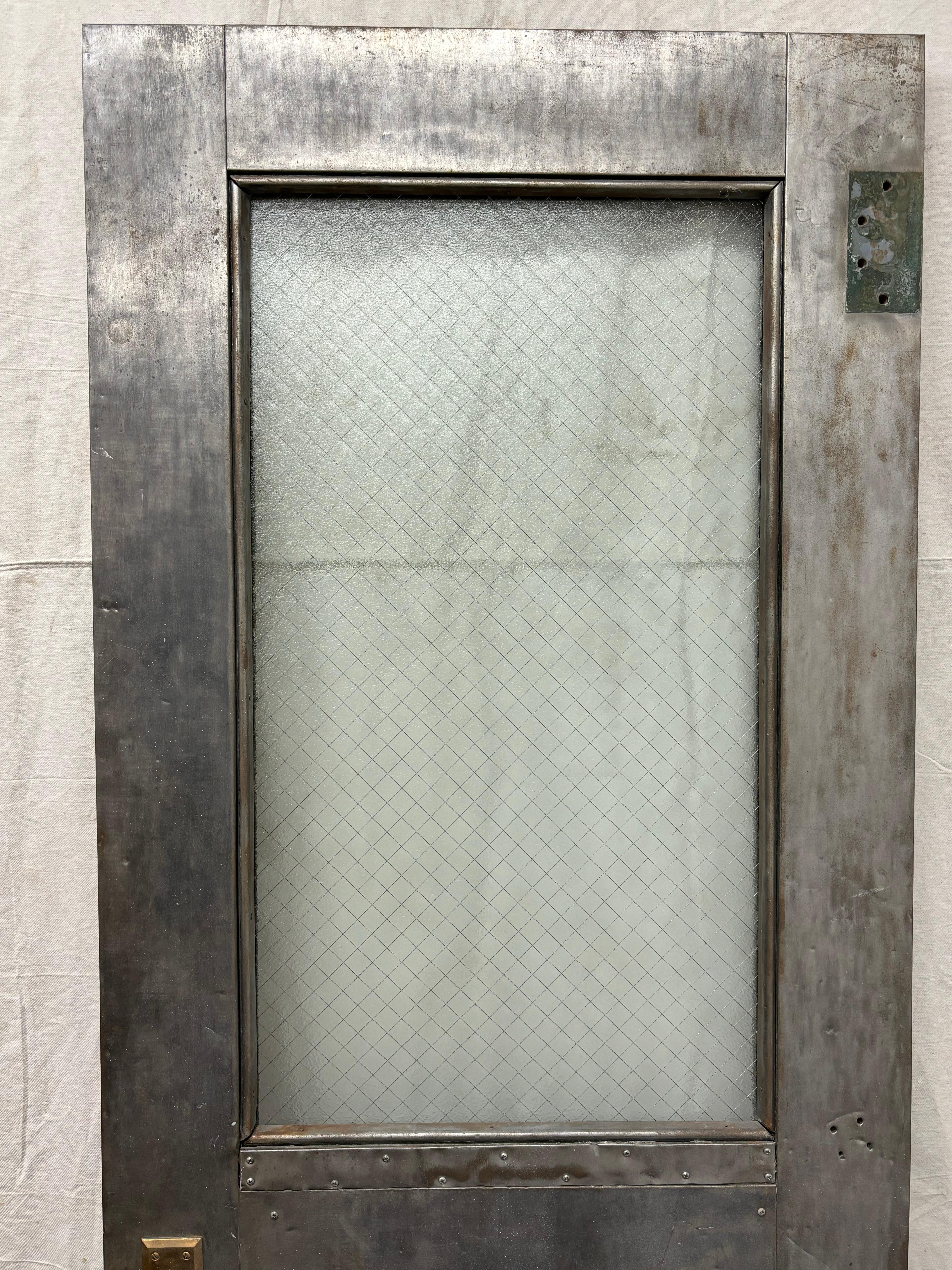Industrial Zinc Clad Wood Door with safety glass panel.  Door includes its original hinges and working, locking hardware.  Great patina!