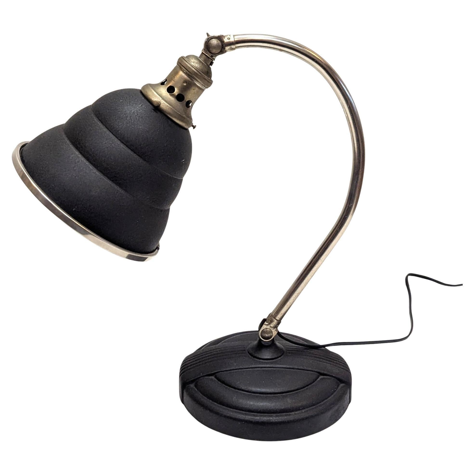 Lampada da scrivania articolata General Electric Industrial Art Deco.  Ha un paralume in alluminio, una base in ghisa, una presa e un braccio nichelati.   Le cerniere girevoli che collegano il braccio al paralume e alla base permettono alla lampada