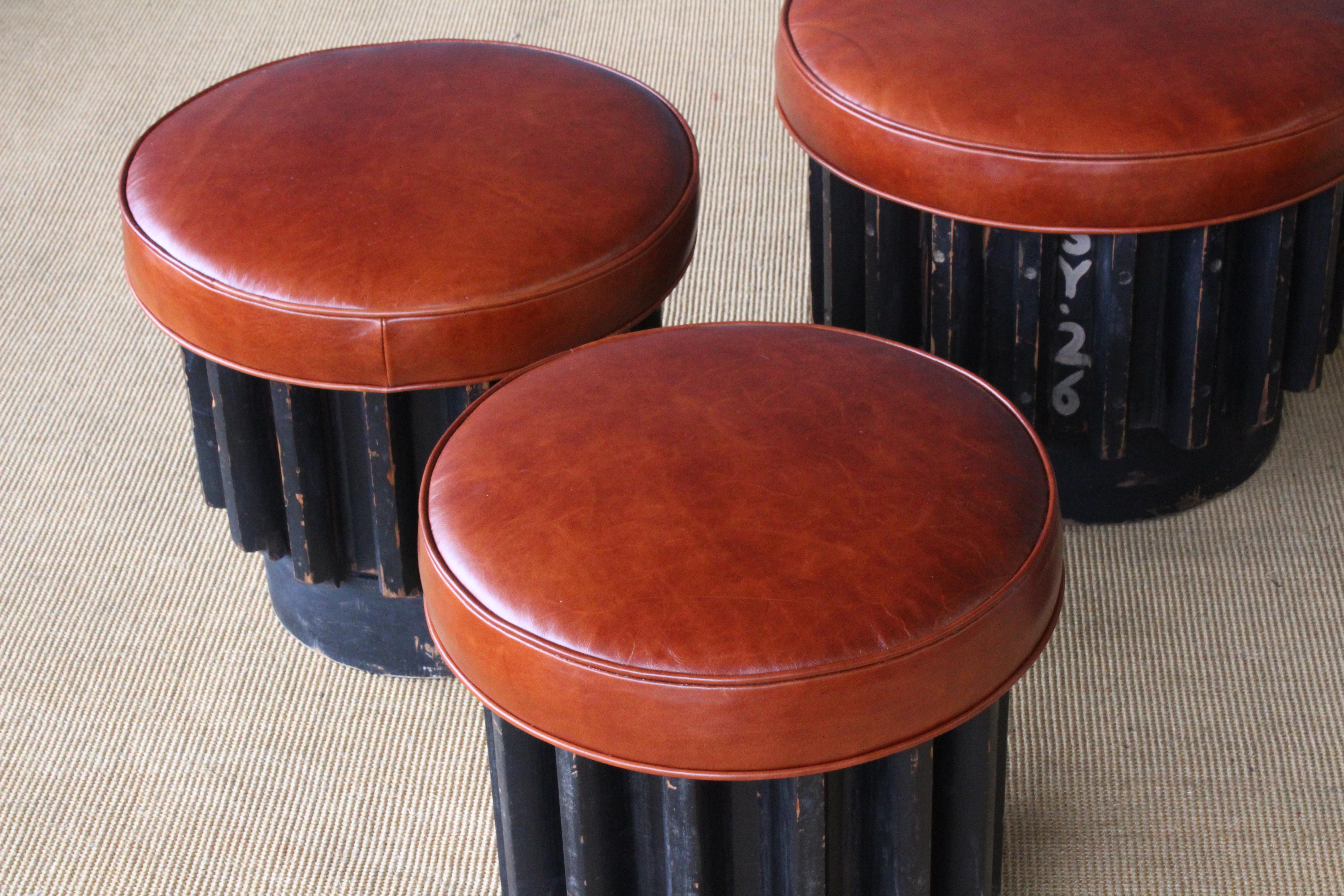 Industrial gear molds, originally from a gear factory from Los Angeles, re-purposed and made into custom stools. Original black painted finish to each stool with age appropriate signs of wear. Each stool has new leather upholstery. Sizes vary, two