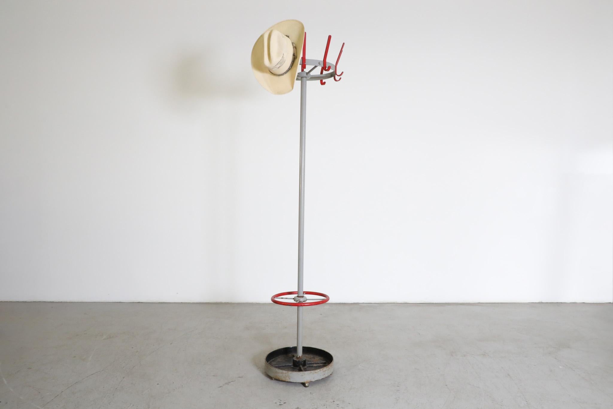 Mid-Century industrial coat rack by by widely acclaimed Dutch furniture manufacturer Gispen.  Outfittede with Red hooks with grey enameled post and a weighted enameled metal base. Heavy duty coat rack with red ring for umbrellas. In original