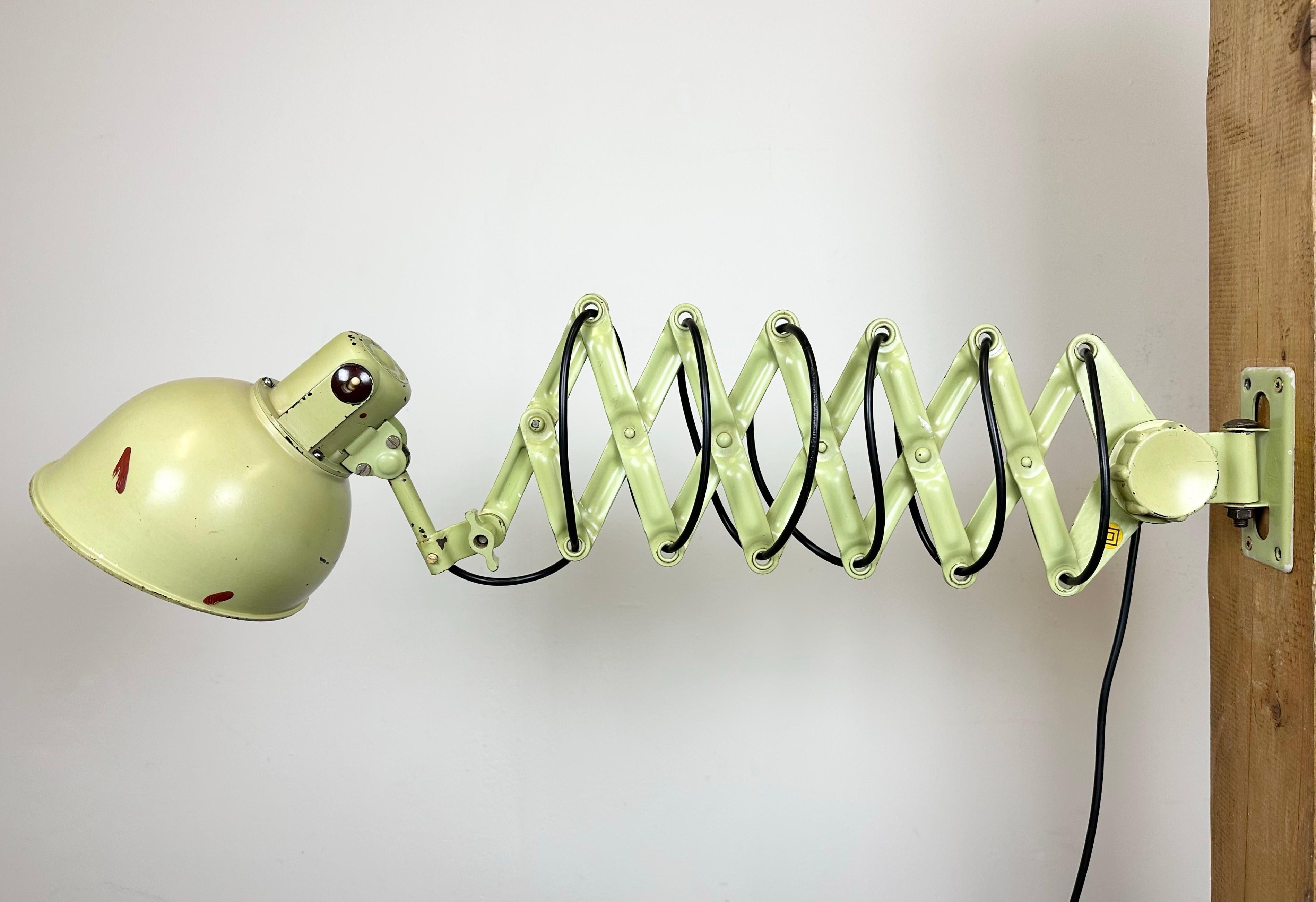 This vintage industrial scissor lamp was produced by REIF DRESDEN in former East Germany during the 1960s. The lamp has a green bakelite shade. Green iron scissor arm is extendable and can be turned sideways. The original socket requires E27/E26