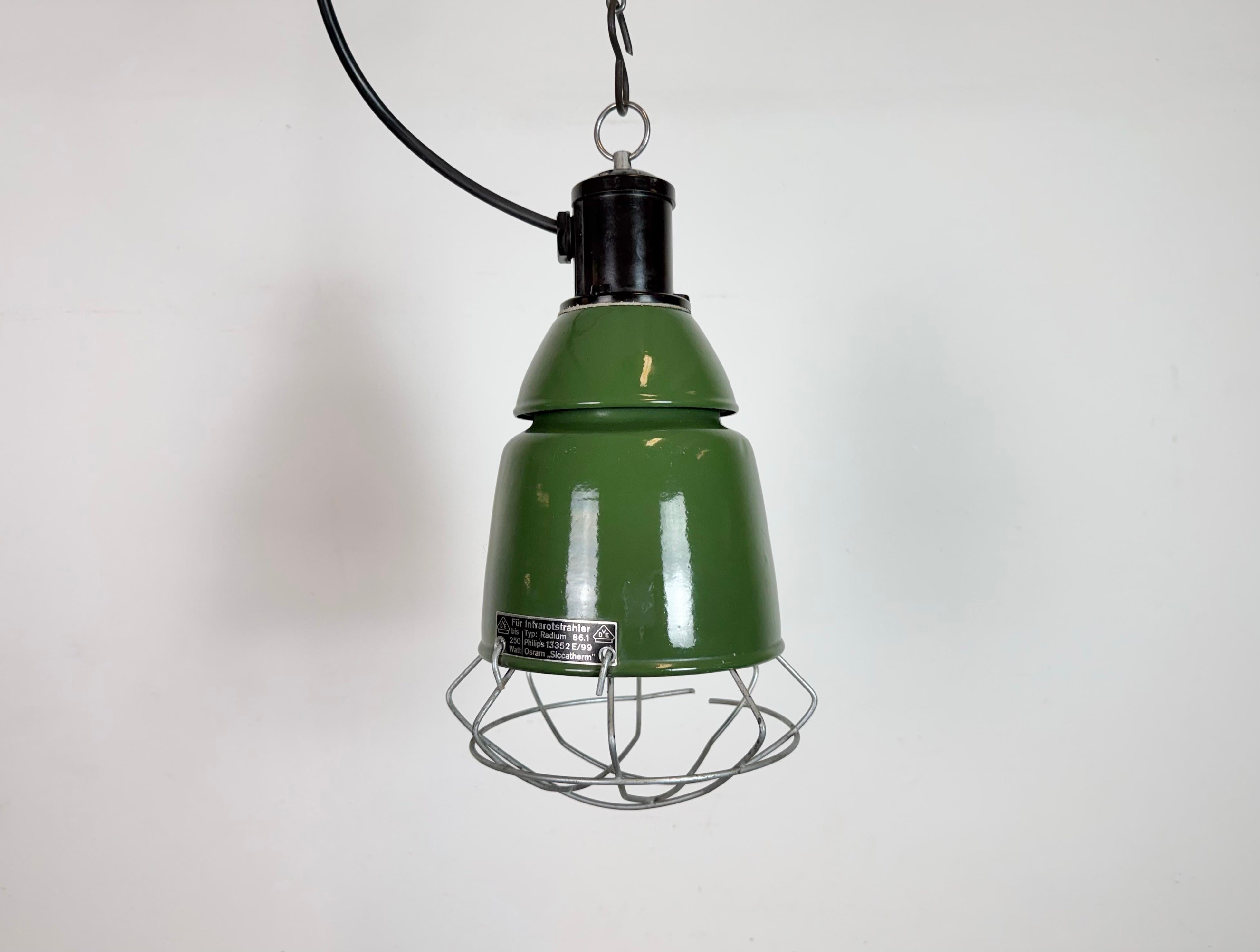 La luce del vecchio fienile veniva utilizzata come luce a infrarossi per tenere al caldo gli animali. Prodotto da Philips in Olanda negli anni '60. Presenta un paralume conico in smalto verde con parte superiore in bachelite e una griglia in ferro.