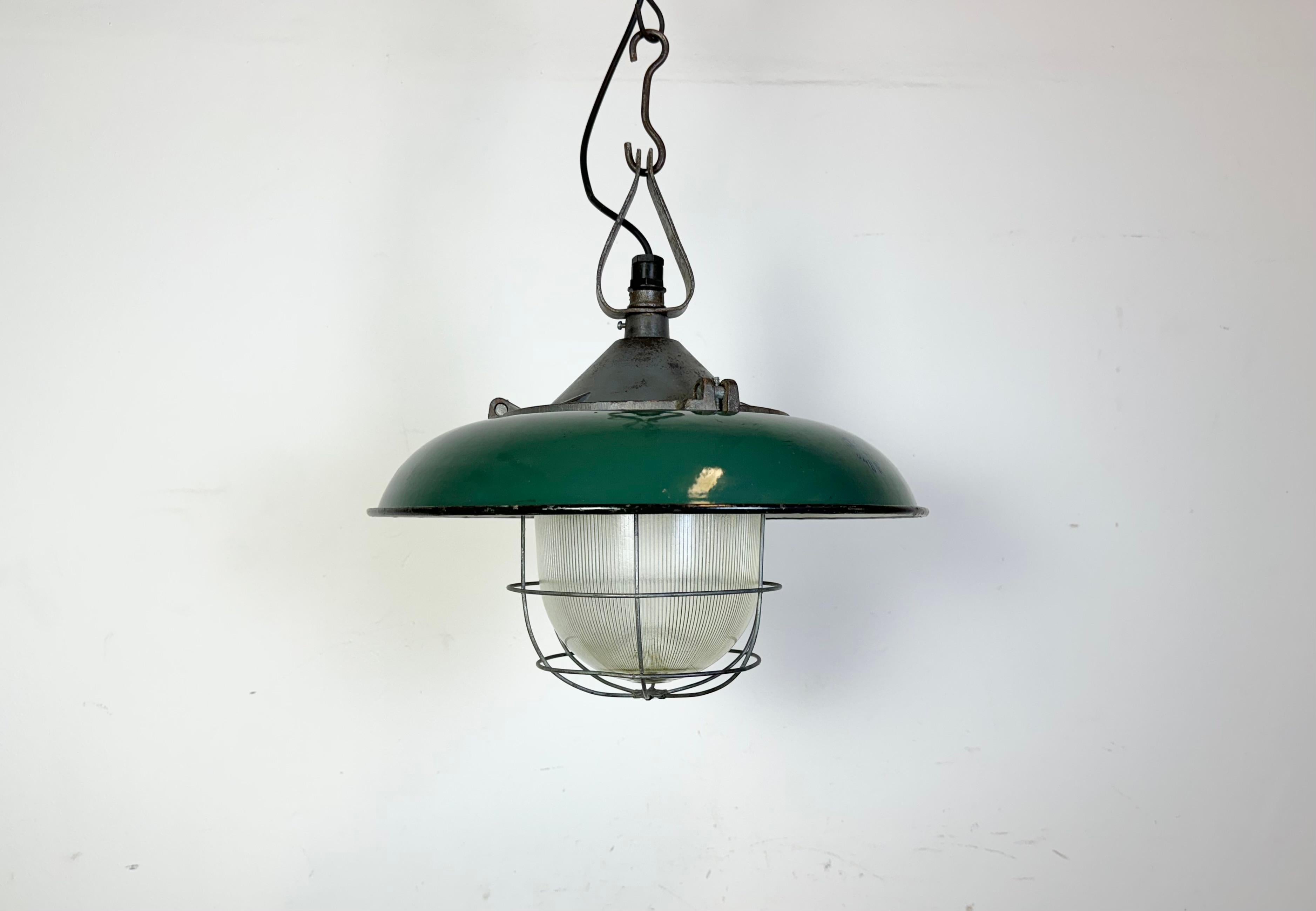 - Industrial factory pendant lamp in cast iron.
- Manufactured by A23 Factory in Wilkasy  in Poland during the 1960s.
- Green enamel shade with white enamel interior.
- Holophane glass cover and iron grid.
- Weight: 6,5 kg.
- New wire.
- Socket