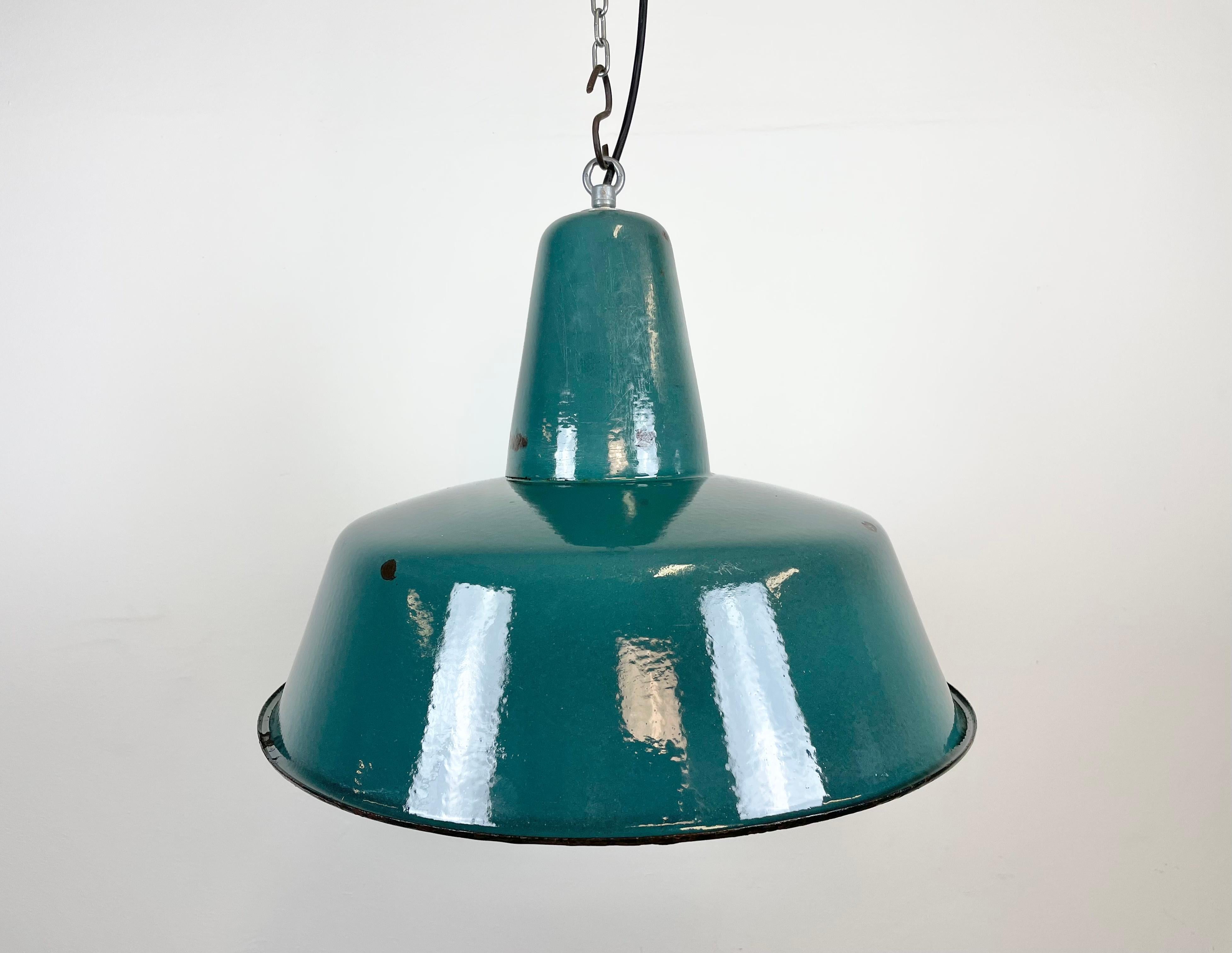 Industrial green enamel pendant light made in Poland during the 1960s. White enamel inside the shade. Iron top. The socket requires E 27 light bulbs. New wire. Fully functional. The weight of the lamp is 1,8 kg.