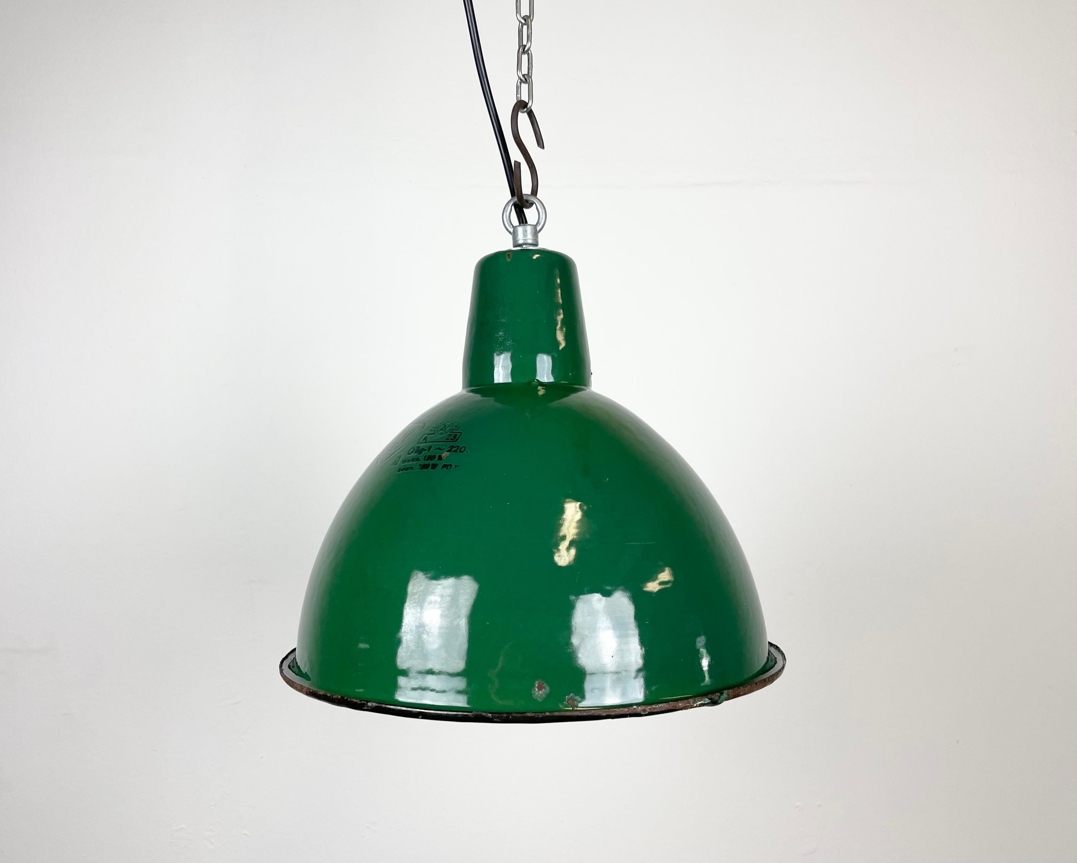 Industrial green enamel pendant light made by Polam Wilkasy in Poland during the 1960s. White enamel inside the shade. Iron top. The porcelain socket requires E 27 light bulbs. New wire. Fully functional. The weight of the lamp is 1 kg.