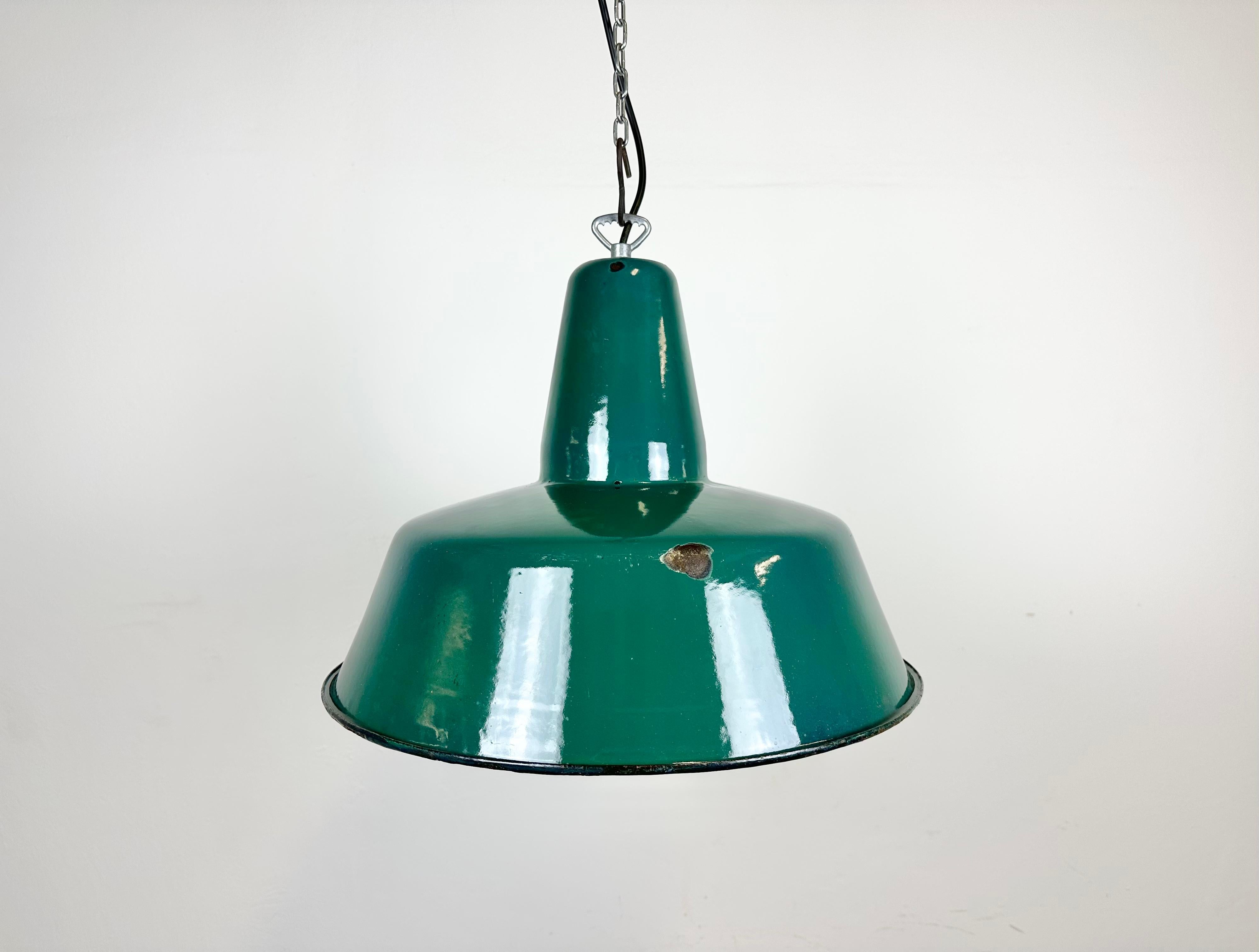 Industrial green enamel pendant light made in Poland during the 1960s. White enamel inside the shade. Iron top. The socket requires E 27/ E 26 light bulbs. New wire. Fully functional. The weight of the lamp is 2 kg.