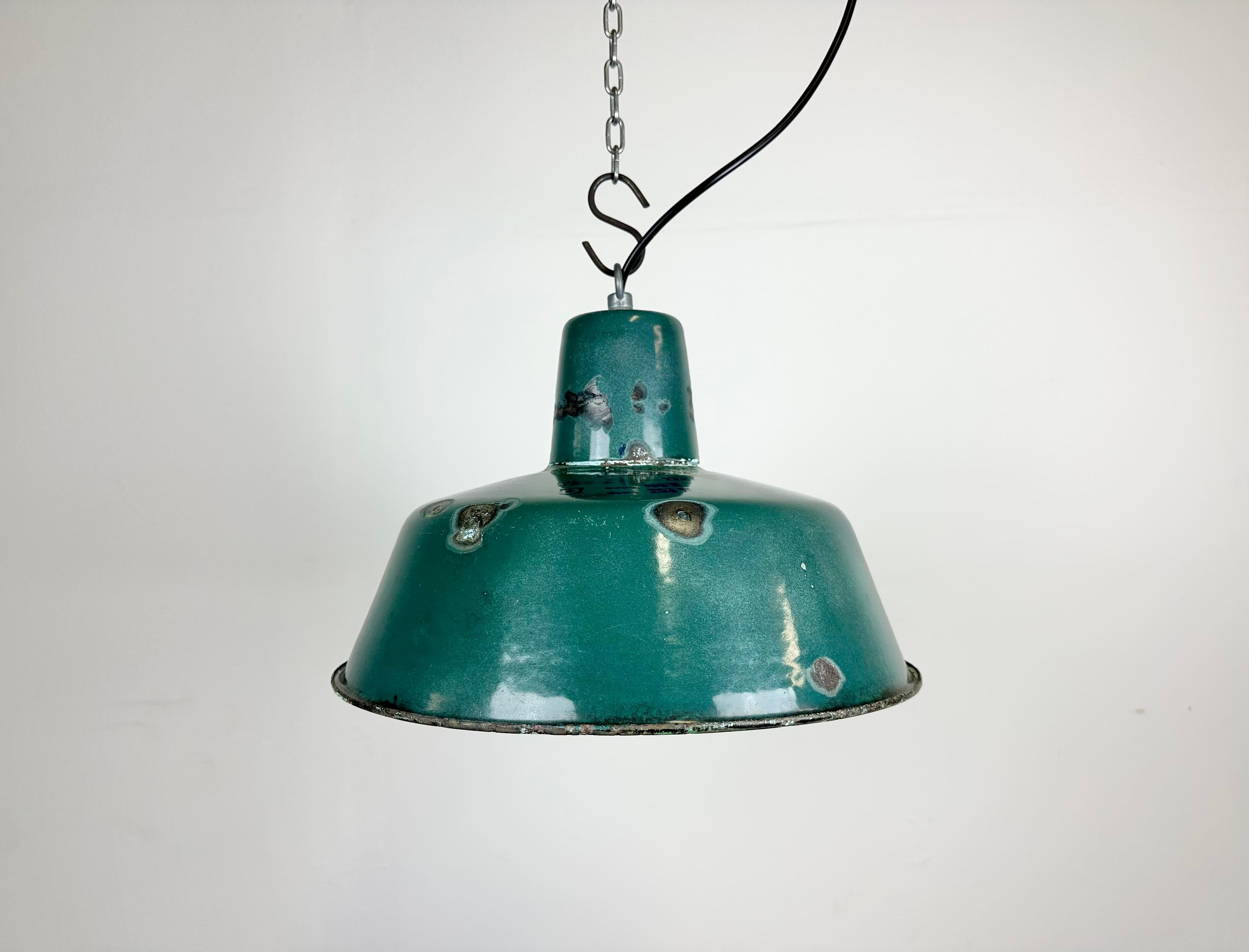 Industrial green enamel pendant light made in Poland during the 1960s. White enamel inside the shade. Iron top. The porcelain socket requires E 27/ E 26 light bulbs. New wire. Fully functional. The weight of the lamp is 1,2 kg.