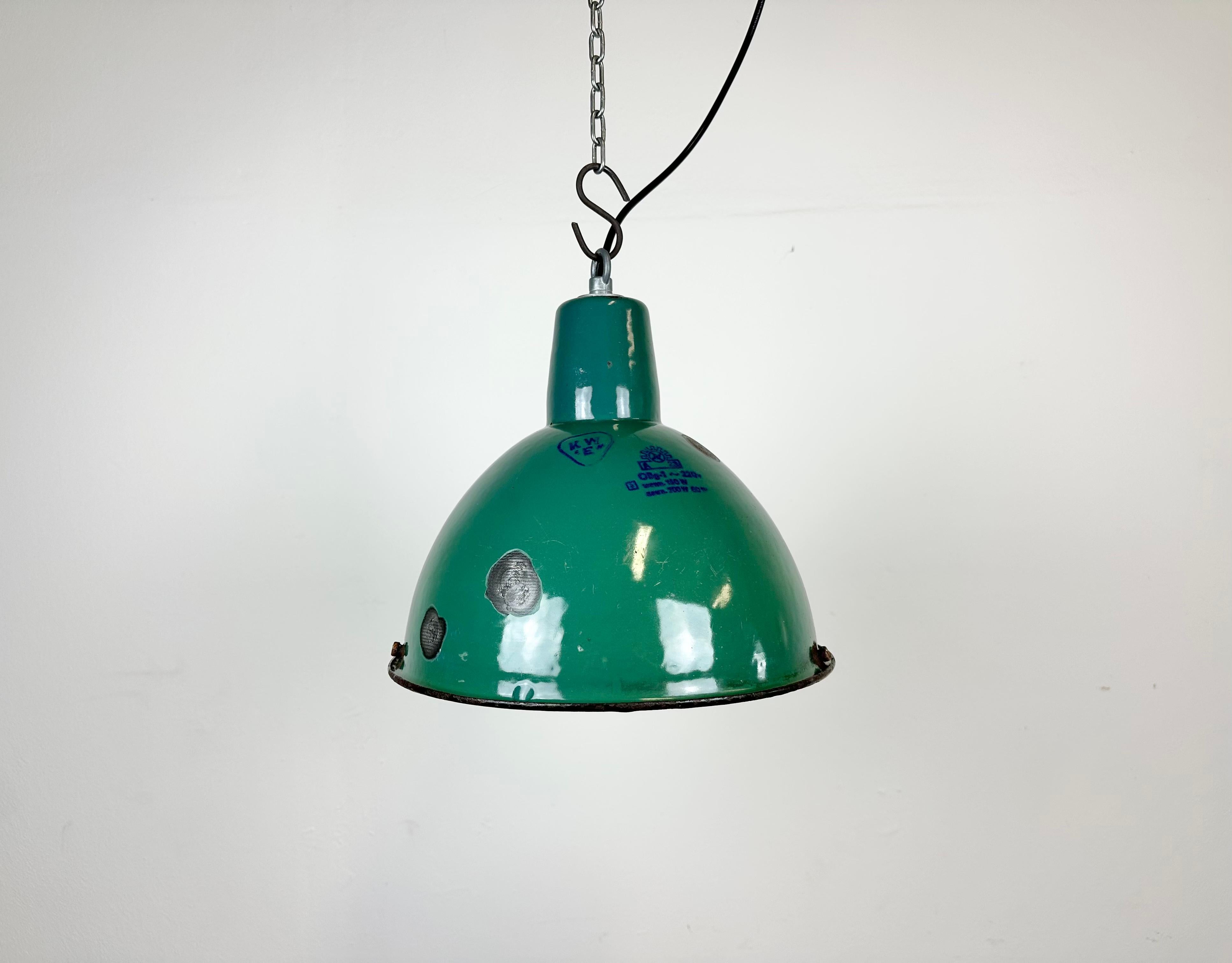 Lampada a sospensione industriale in smalto verde realizzata da Polam Wilkasy in Polonia negli anni Sessanta. Smalto bianco all'interno del paralume. Top in ferro. L'attacco in porcellana richiede lampadine E 27. Un nuovo cavo. Completamente