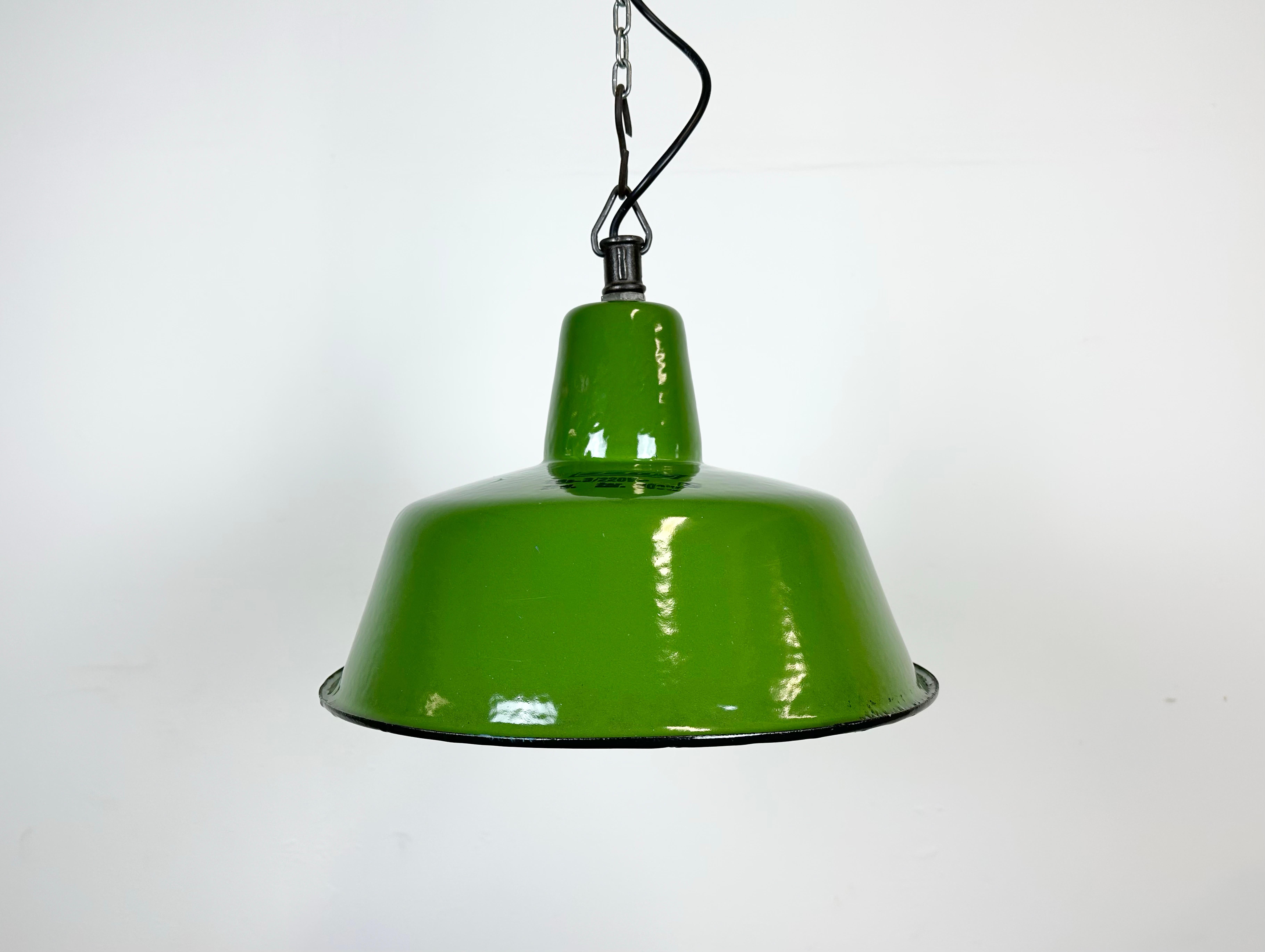 Industrial green enamel pendant light made by Zaos in Poland during the 1960s. White enamel inside the shade. Cast iron top. The porcelain socket requires E 27/ E 26 light bulbs. New wire. Fully functional. The weight of the lamp is 1,5 kg.
