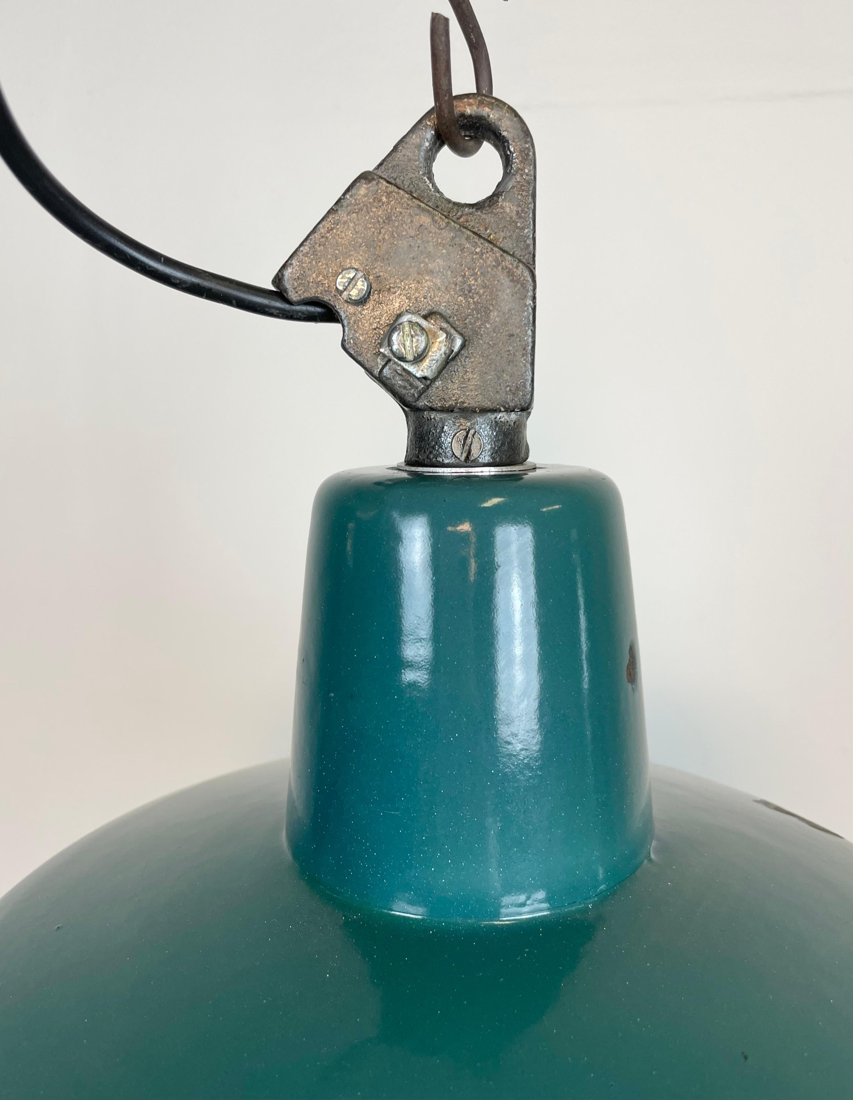 Industrial green enamel pendant light made by Polam Wilkasy in Poland during the 1960s. White enamel inside the shade. Cast iron top. The porcelain socket requires E 27/ E 26 light bulbs. New wire. Fully functional. The weight of the lamp is 1,5 kg.