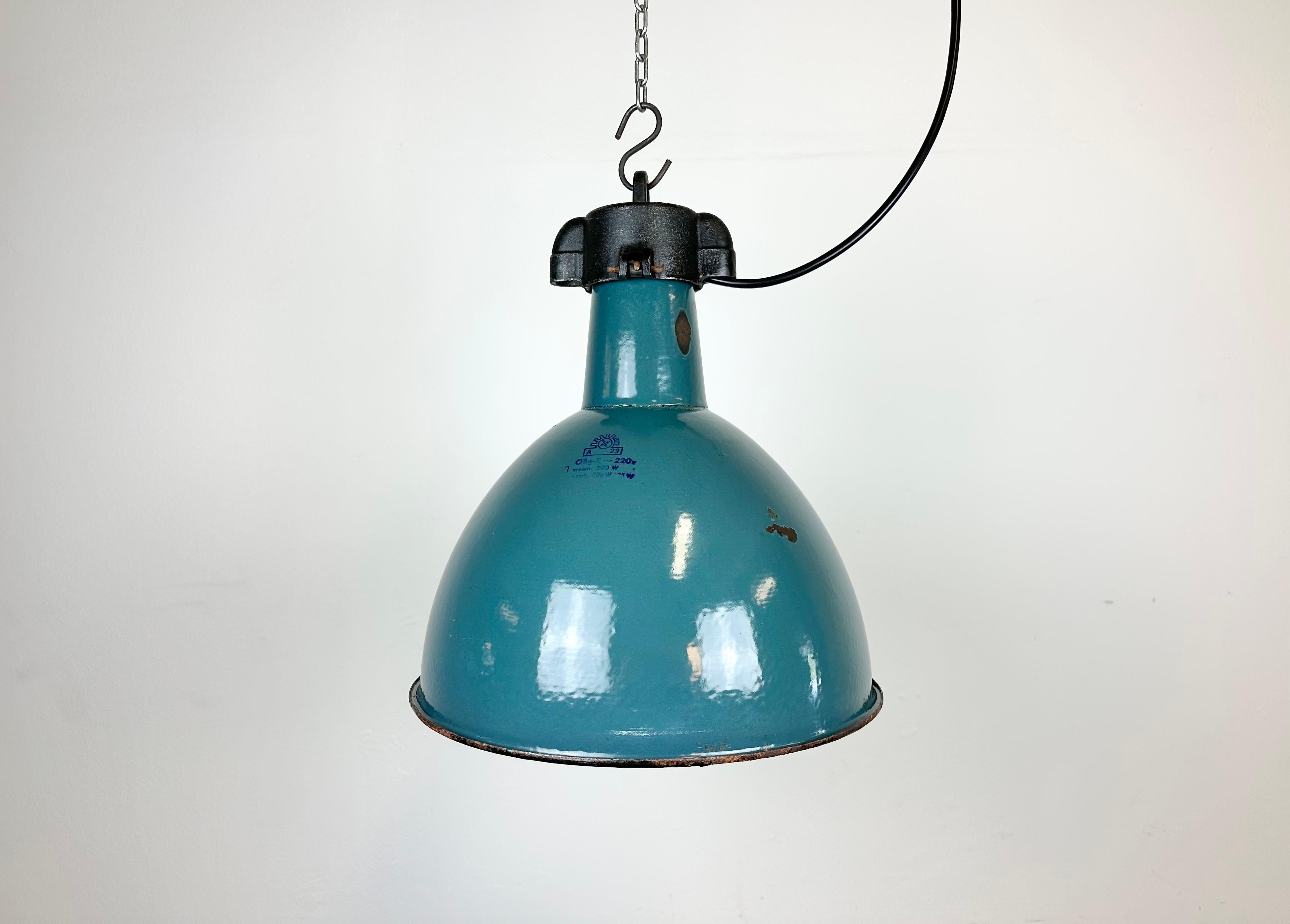 Industrial green enamel pendant light made by Polam Wilkasy in Poland during the 1960s. White enamel inside the shade. Cast iron top. The porcelain socket requires E 27/ E 26 light bulbs. New wire. Fully functional. The weight of the lamp is 2,3 kg.