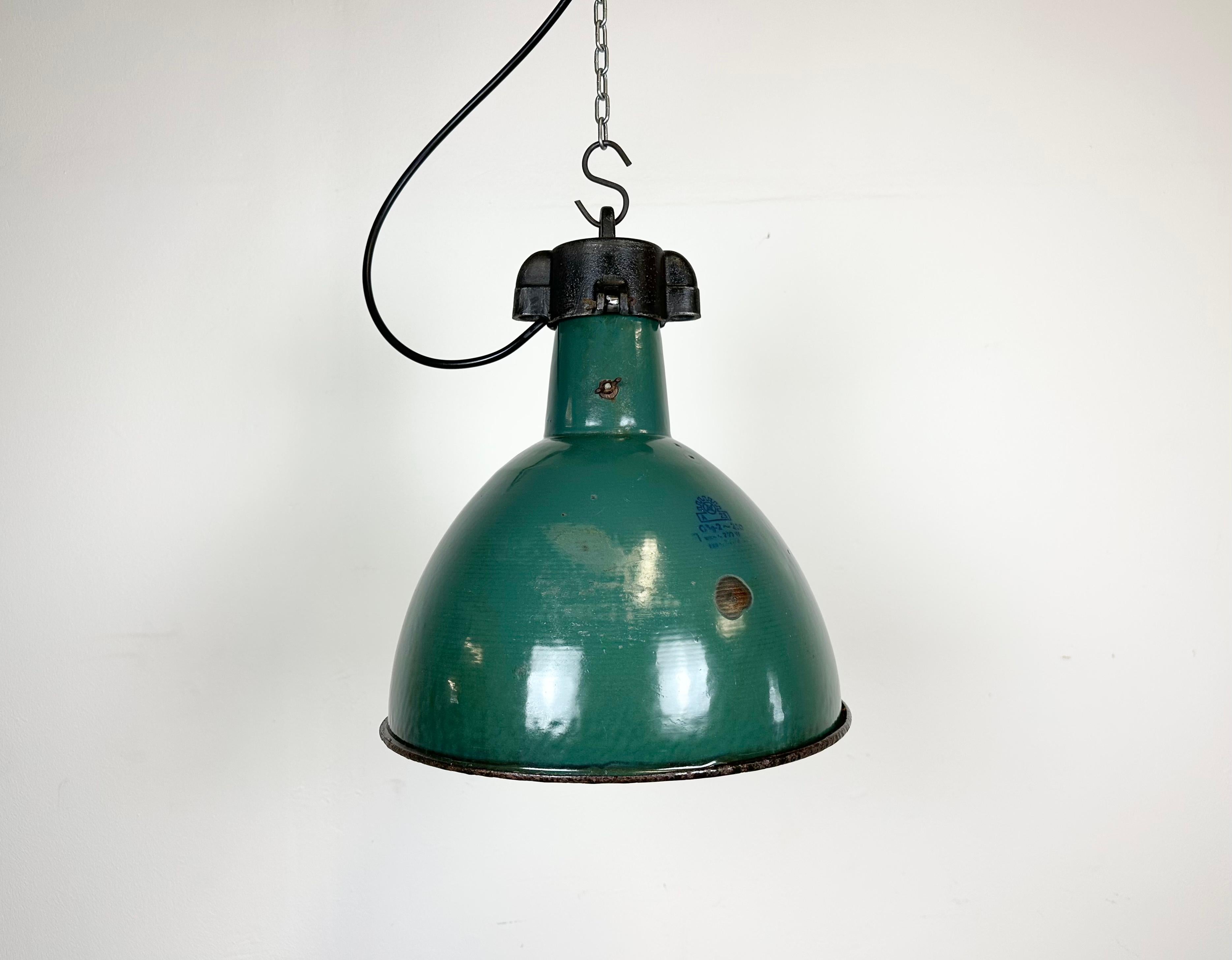 Industrial green enamel pendant light made by Polam Wilkasy in Poland during the 1960s. White enamel inside the shade. Cast iron top. The porcelain socket requires E 27/ E 26 light bulbs. New wire. Fully functional. The weight of the lamp is 2,3 kg.