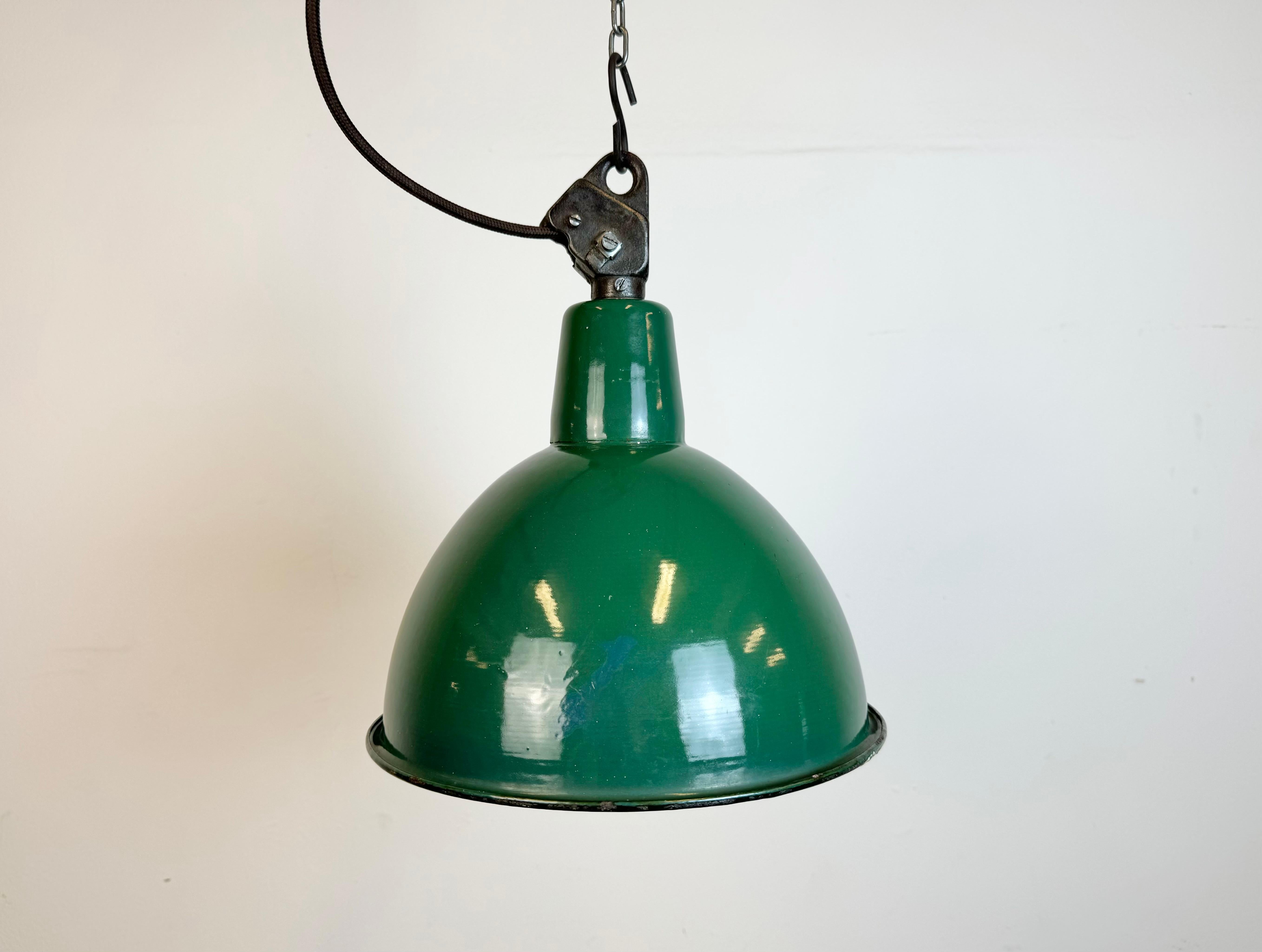 Industrial green enamel pendant light made by A23 factory in Wilkasy in Poland during the 1960s. White enamel inside the shade. Cast iron top. The porcelain socket requires standard E 27/ E26 light bulbs. New wire. Fully functional. The weight of