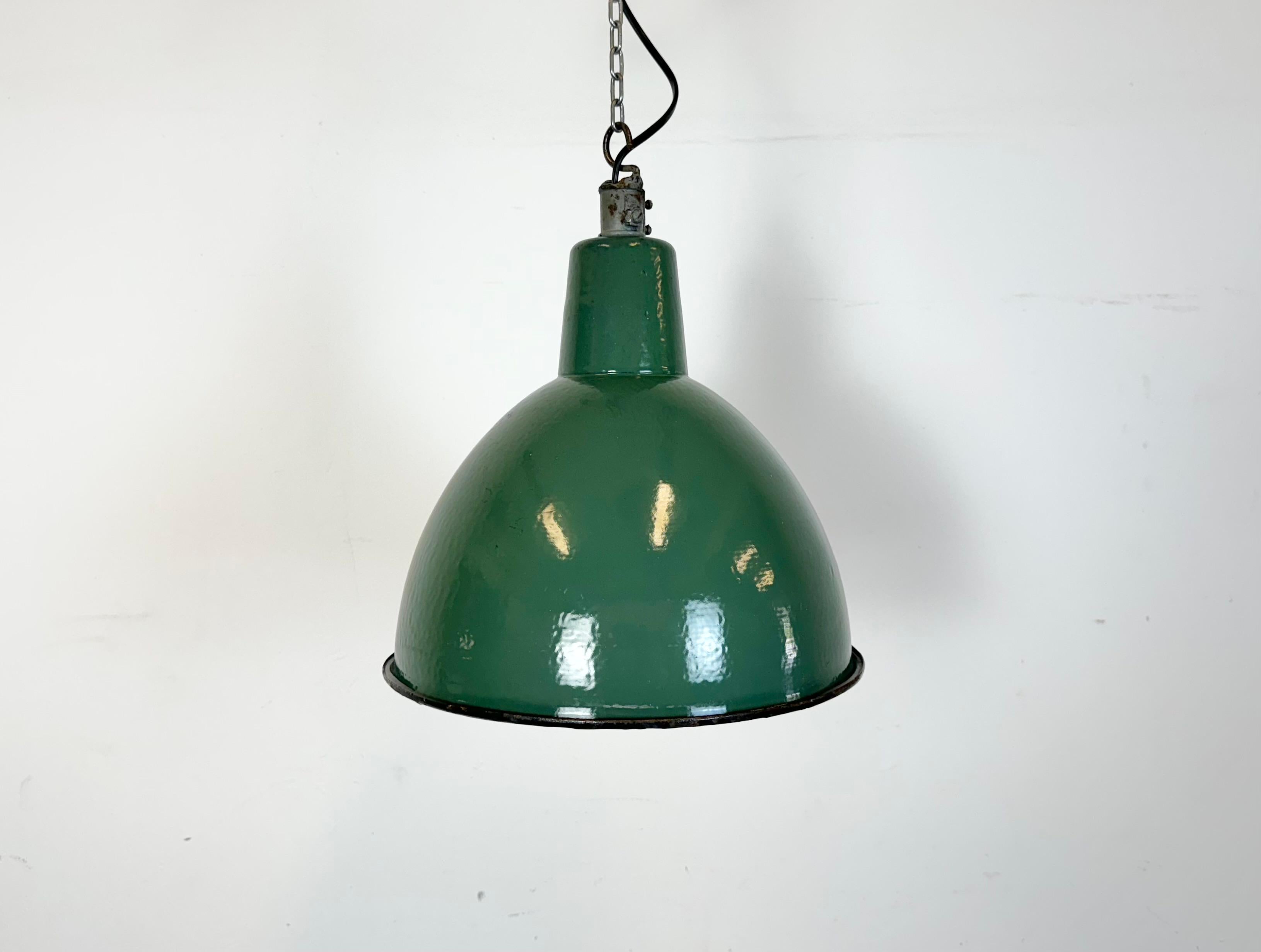 Pendelleuchte aus grüner Emaille, hergestellt in der Fabrik A23 in Wilkasy in Polen in den 1960er Jahren. Weiße Emaille im Inneren des Schirms. Bügelverschluss. Die Porzellanfassung ist für handelsübliche Glühbirnen E 27/ E26 geeignet. Neues Kabel.